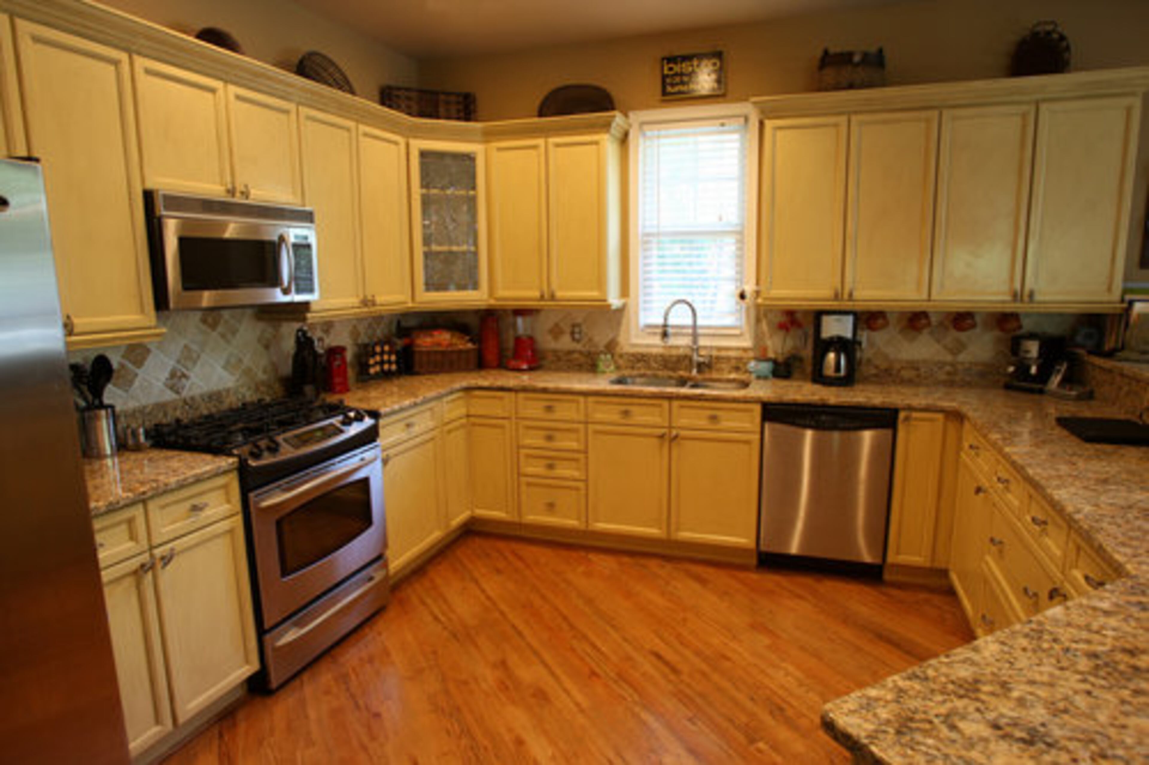 A breakfast bar opens to the kitchen, where the Eskews tea-stained the cabinets to give them an antique finish. They added granite counter tops with a tile backsplash.