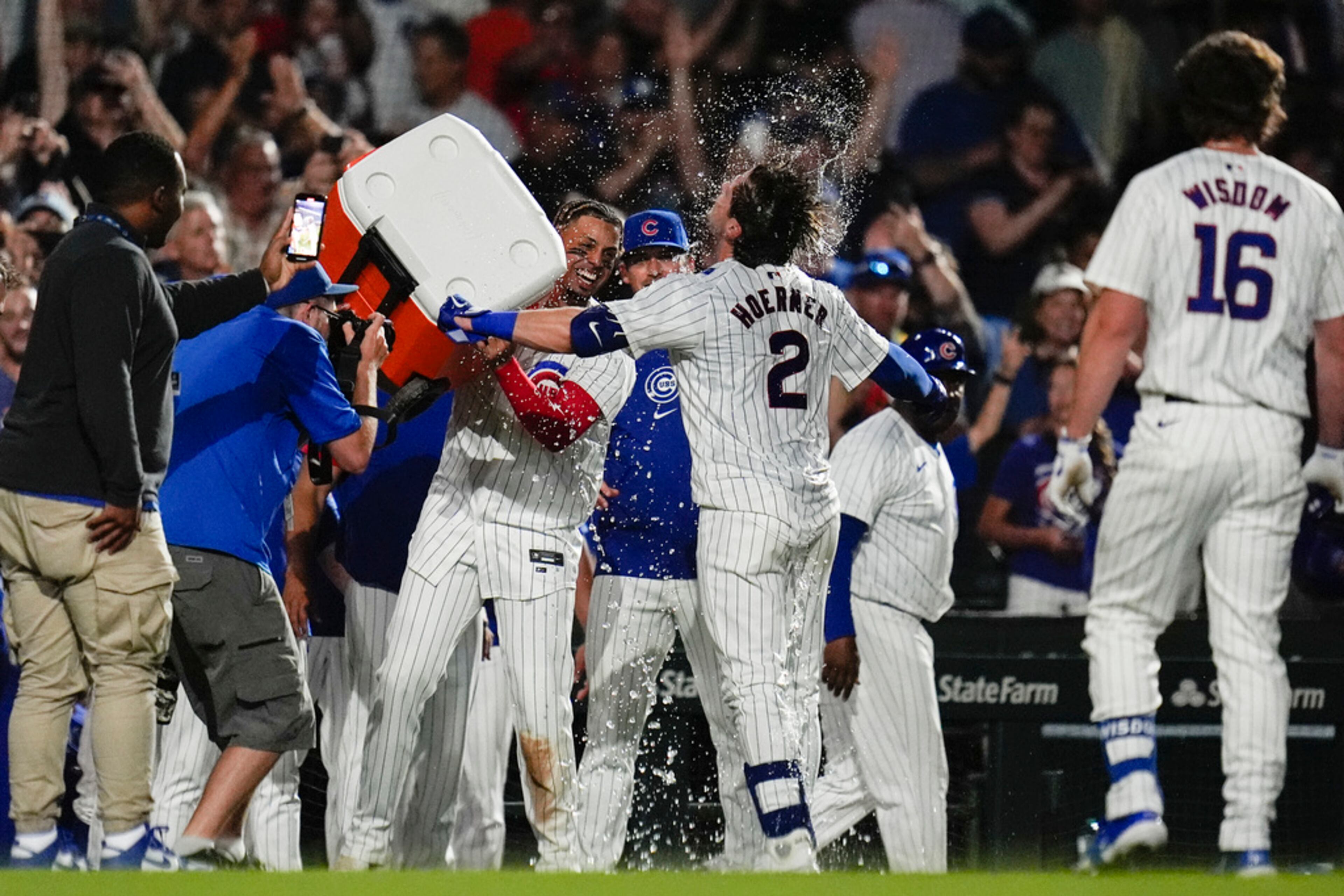 Chicago Cubs' Nico Hoerner is doused with water after he hit a single, allowing Cody Bellinger to score and win the game 4-3 over the Atlanta Braves during the tenth inning of a baseball game Tuesday, May 21, 2024, in Chicago. (AP Photo/Erin Hooley)