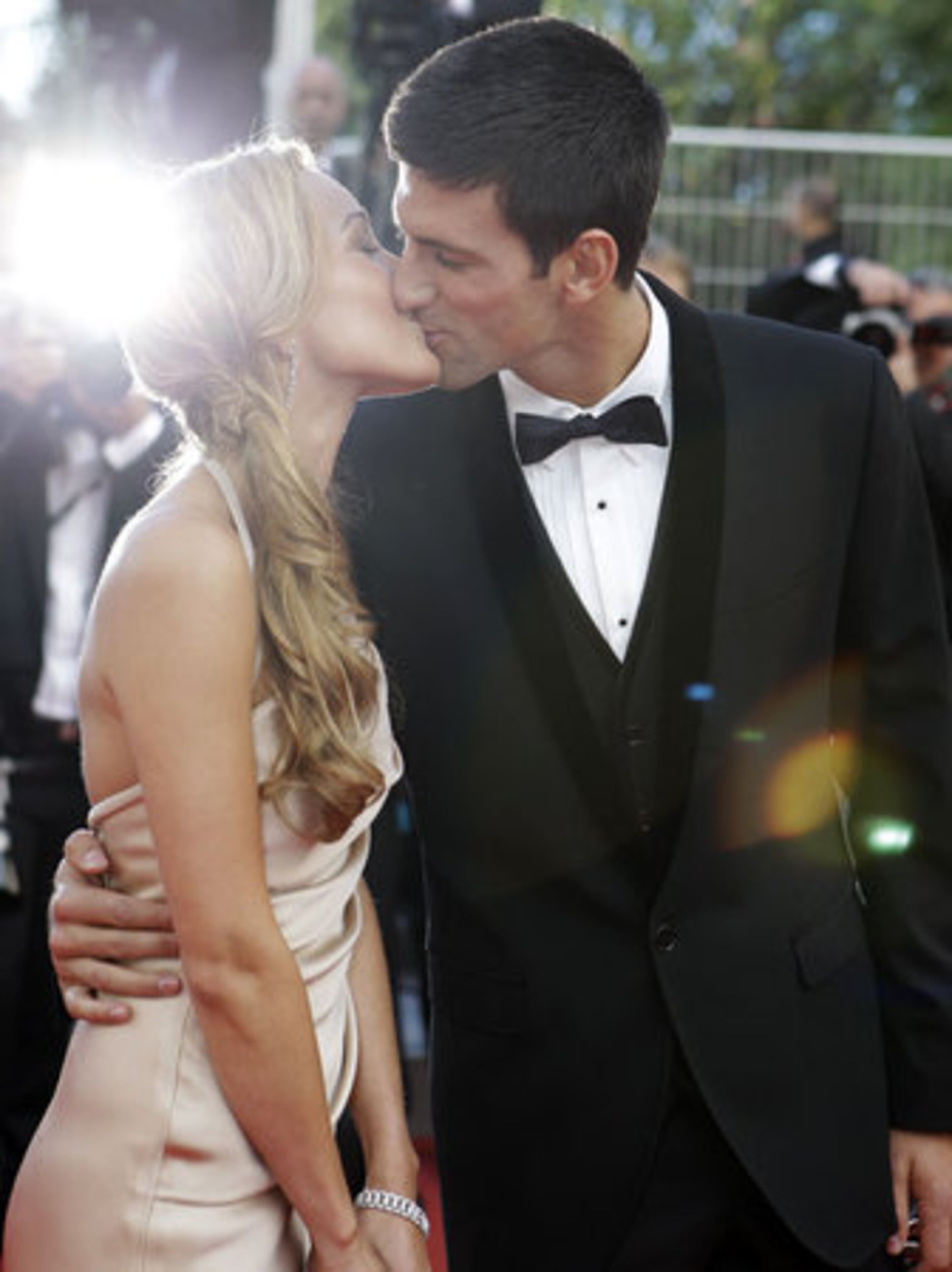 Tennis player Novak Djokovic, right, kisses his girlfriend Jelena Ristic on the red carpet.