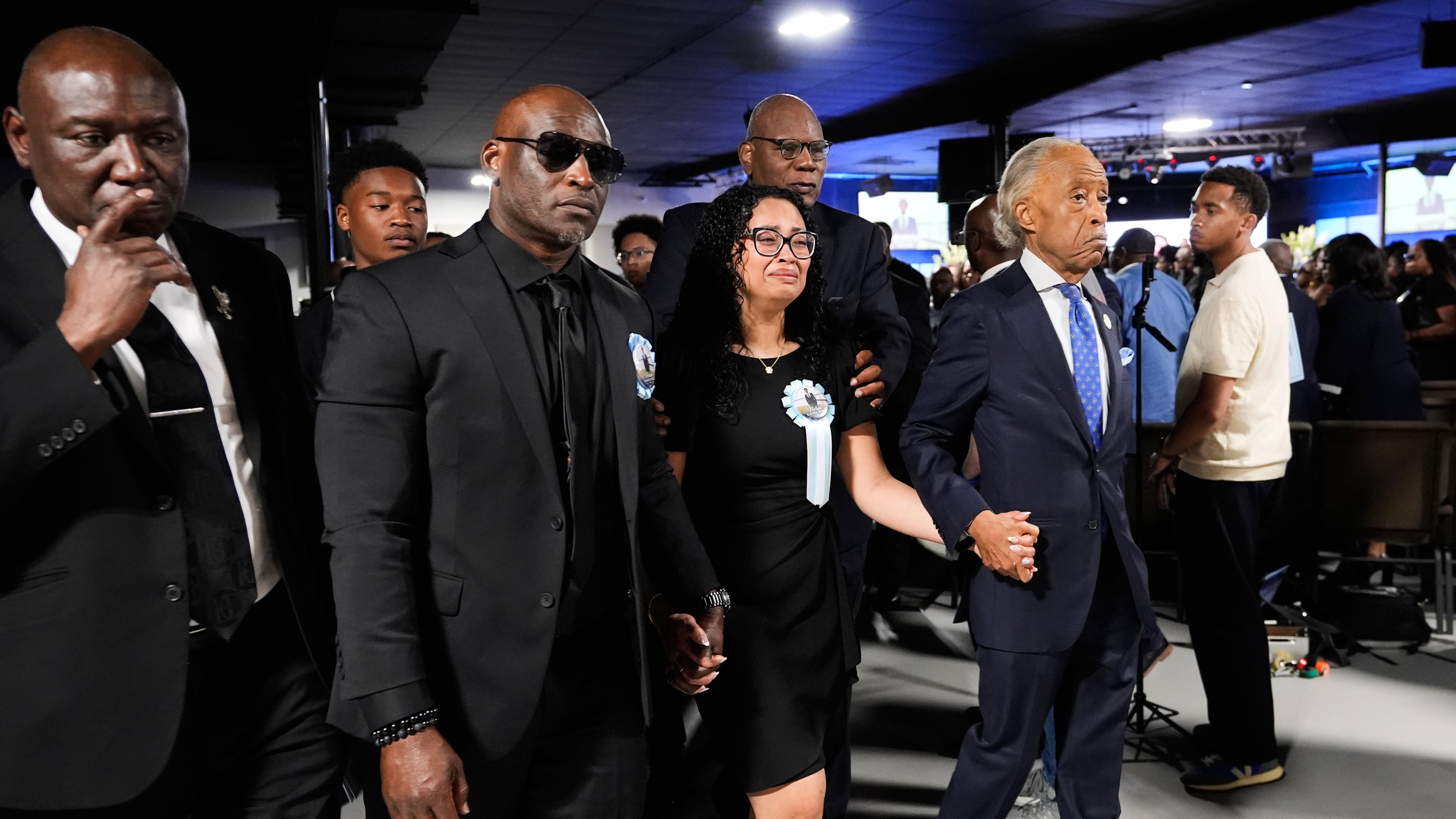 Christine Wonsley, center, walks with Rev. Al Sharpton, right, her husband Elmore, second from left, and attorney Ben Crump, left, during a memorial service for her son Nolan Xavier Wells, an 18-year-old found dead after taking a July 4 boat trip with friends, Monday, July 20, 2026, in Ocean Springs, Miss. (AP Photo/Gerald Herbert)