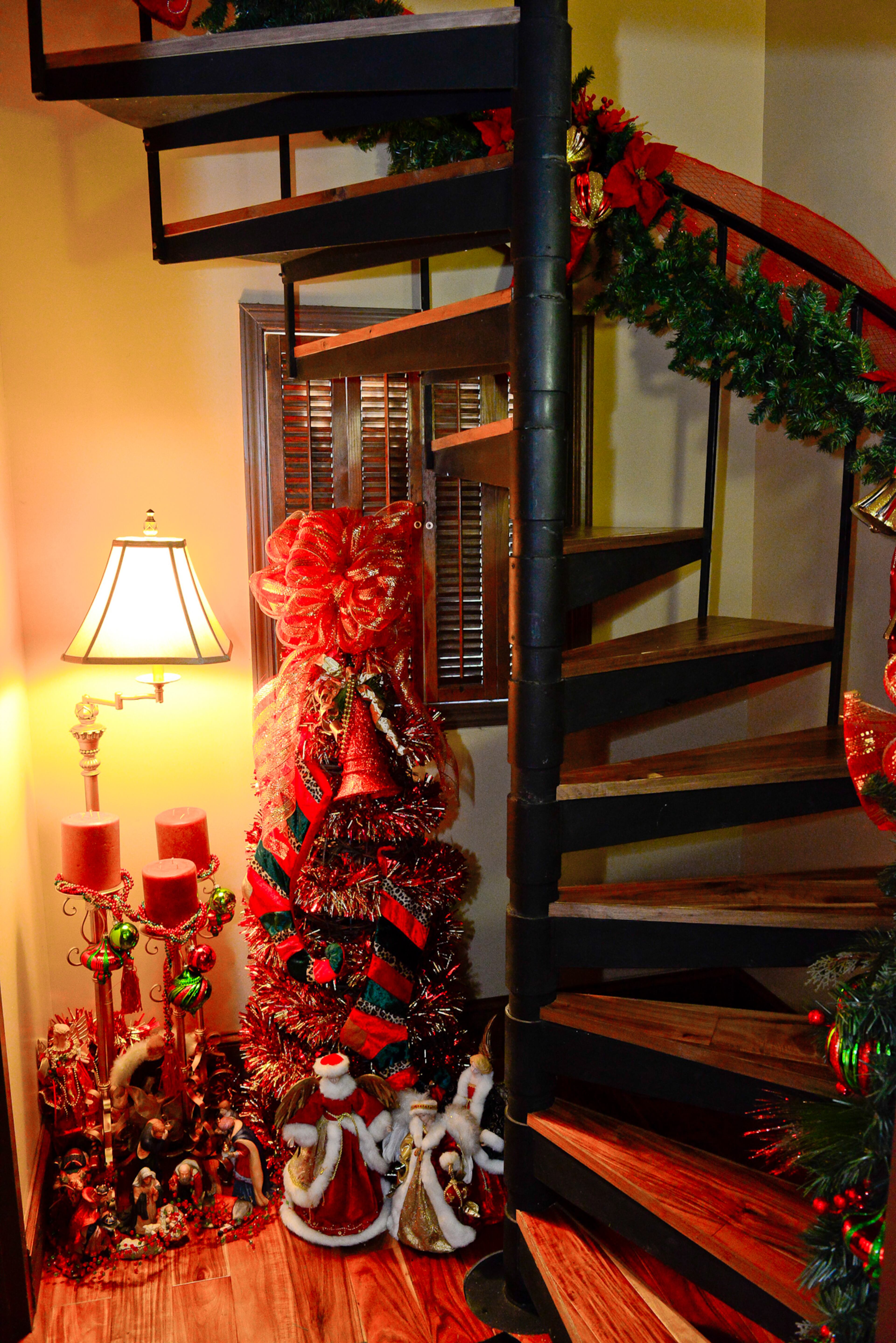 The spiral staircase located at one entryway to the home isn't ignored in the decorations. A smaller tree - one of more than a dozen in the house - and garland up the stairwell all were crafted by homeowner Marcelle Rolan.