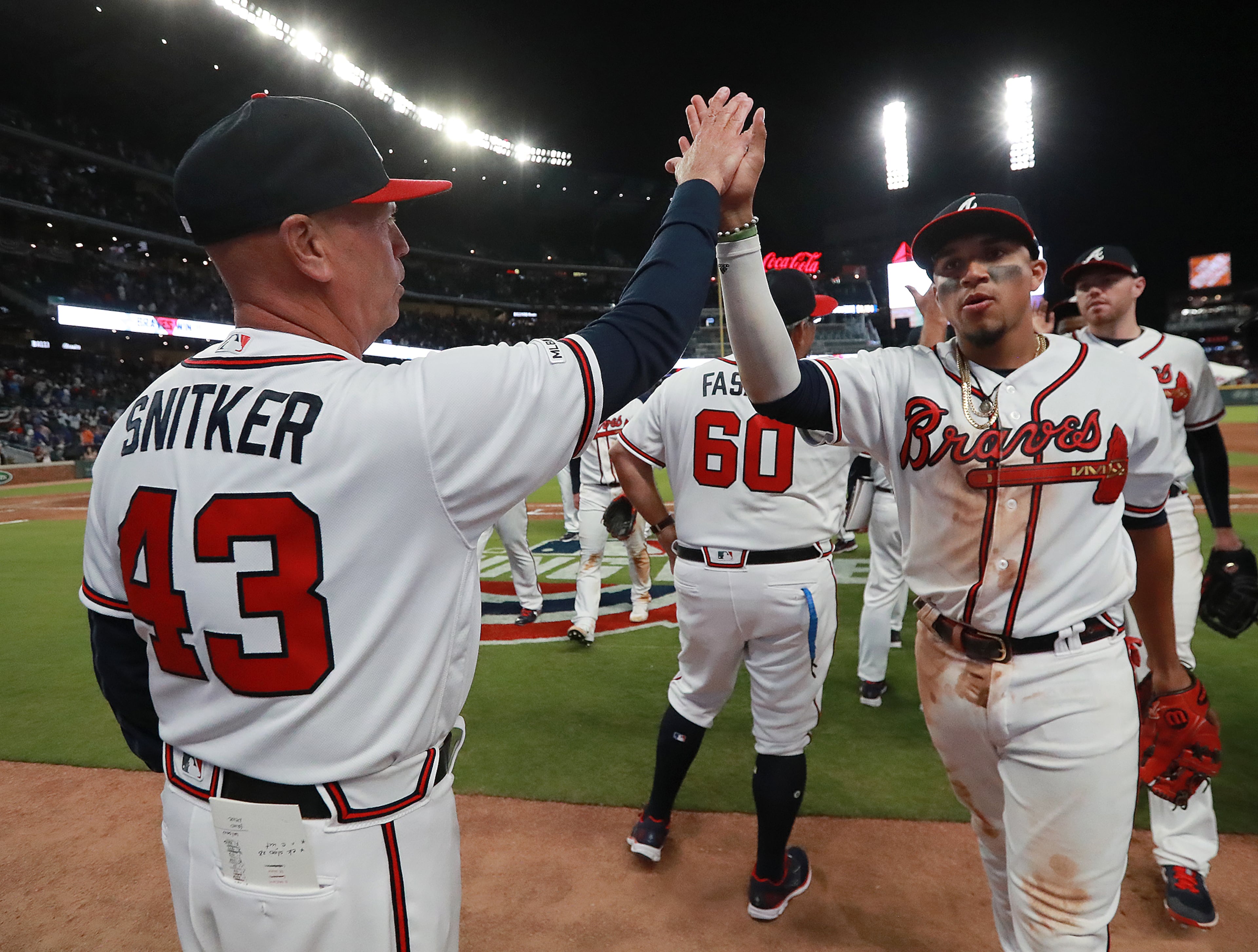 Braves' Johan Camargo (right) get five from manager Brian Snitker after beating the Chicago Cubs 6-4. Curtis Compton/ccompton@ajc.com