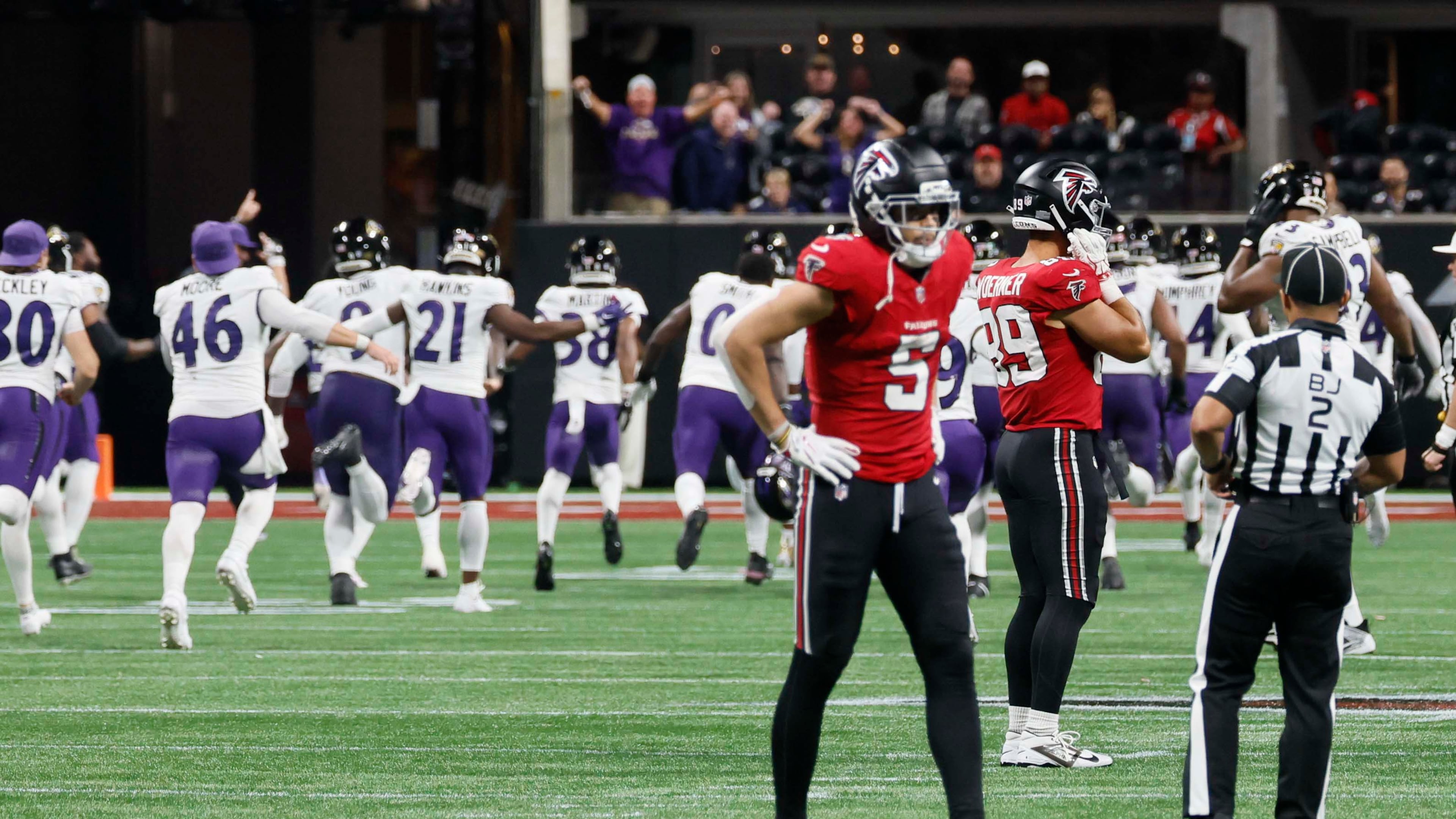 Ravens players rush the field to celebrate beating the Falcons on an overtime interception by Atlanta backup quarterback Tua Tagovailoa (right) on Sunday, Oct. 11, 2026, at Mercedes-Benz Stadium in Atlanta. (Miguel Martinez/AJC)