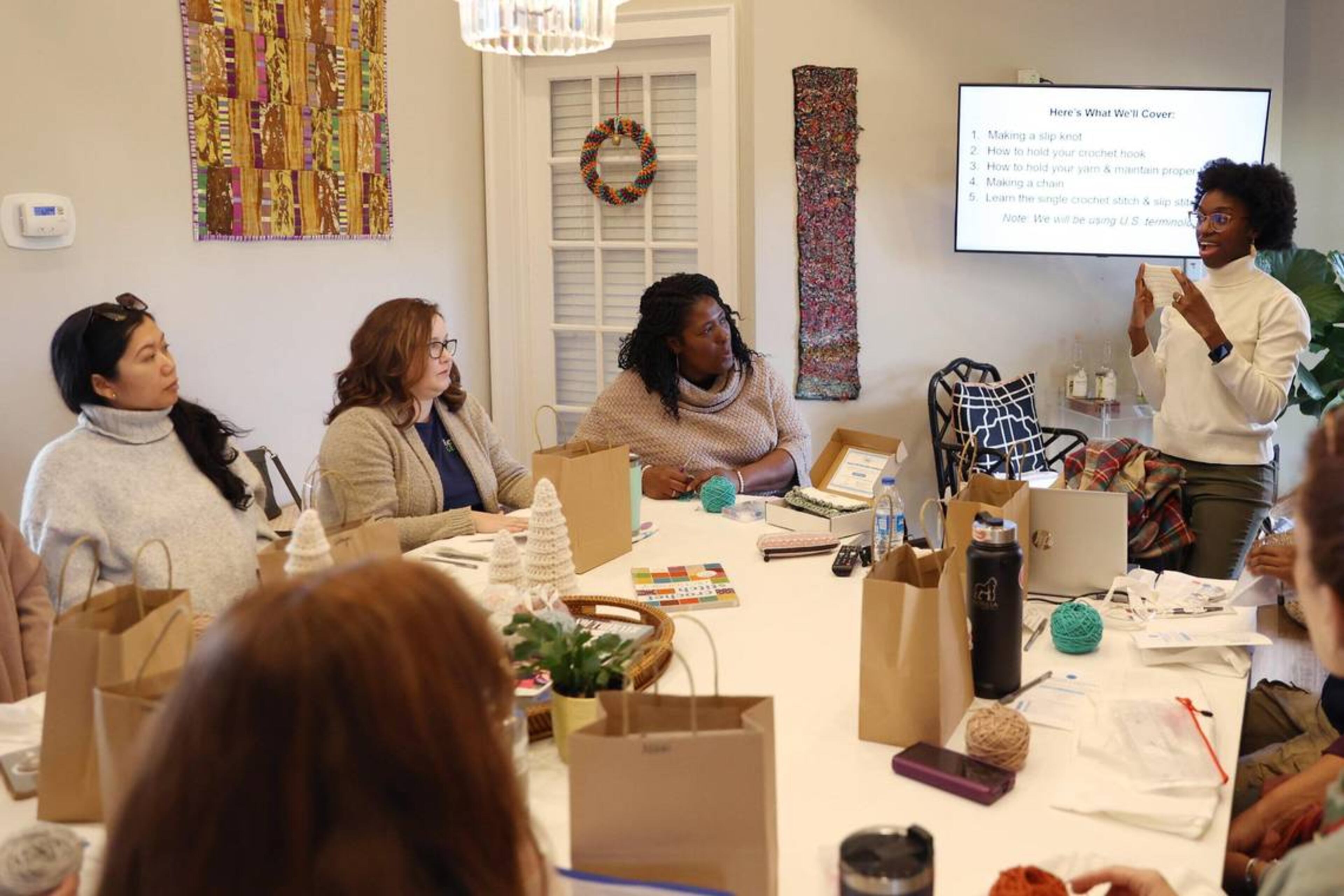 Judah David Creations owner Darice Oppong shows team members from Resilient Middle Georgia a single crochet stitch in her beginner crochet class on Wednesday, Dec. 11, 2024, at The Web in Macon, Georgia. (Photo Courtesy of Katie Tucker/The Telegraph)