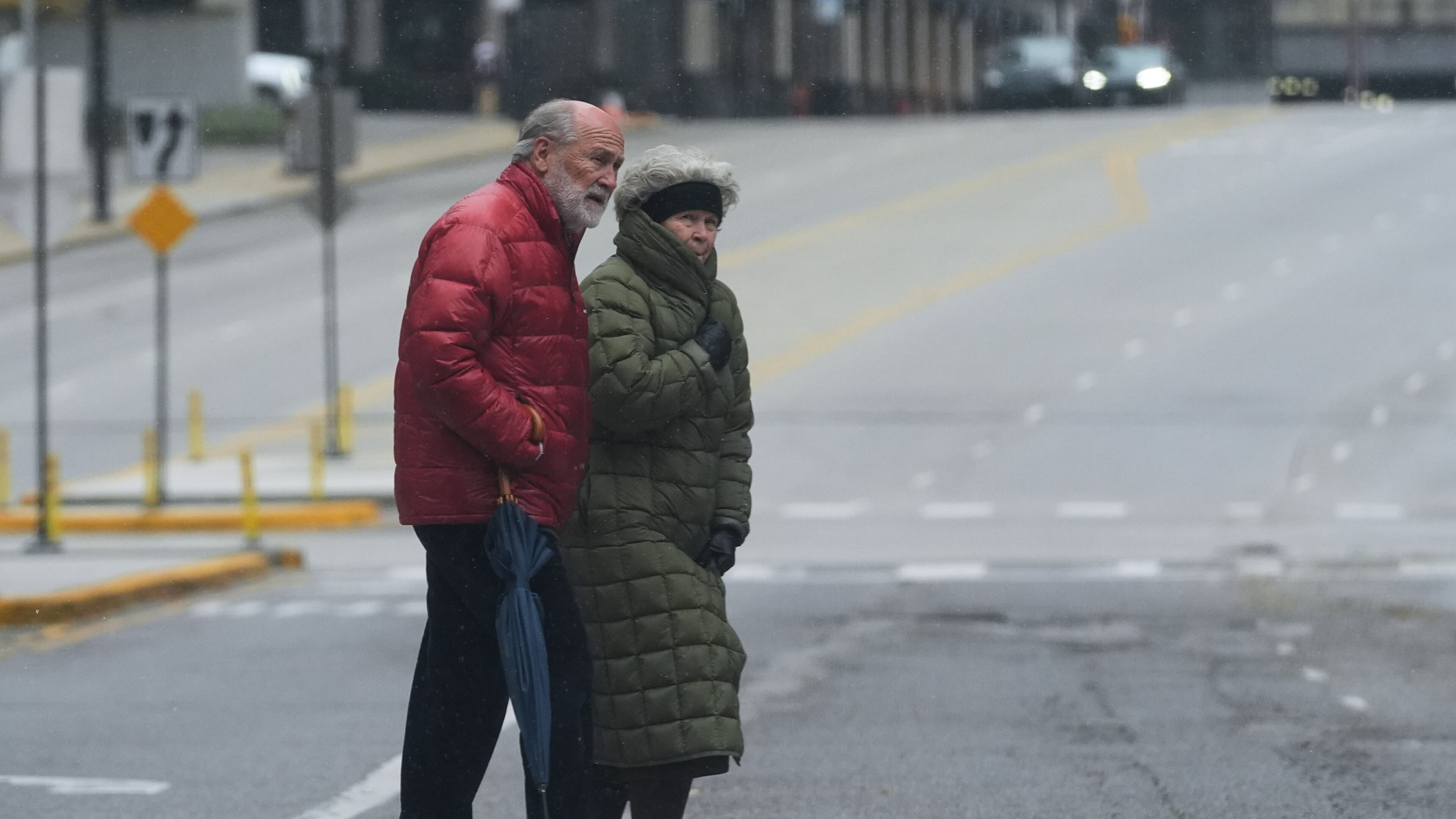Pedestrians cross a street during a cold day in Chicago, Sunday, Nov. 9, 2025. (AP Photo/Nam Y. Huh)