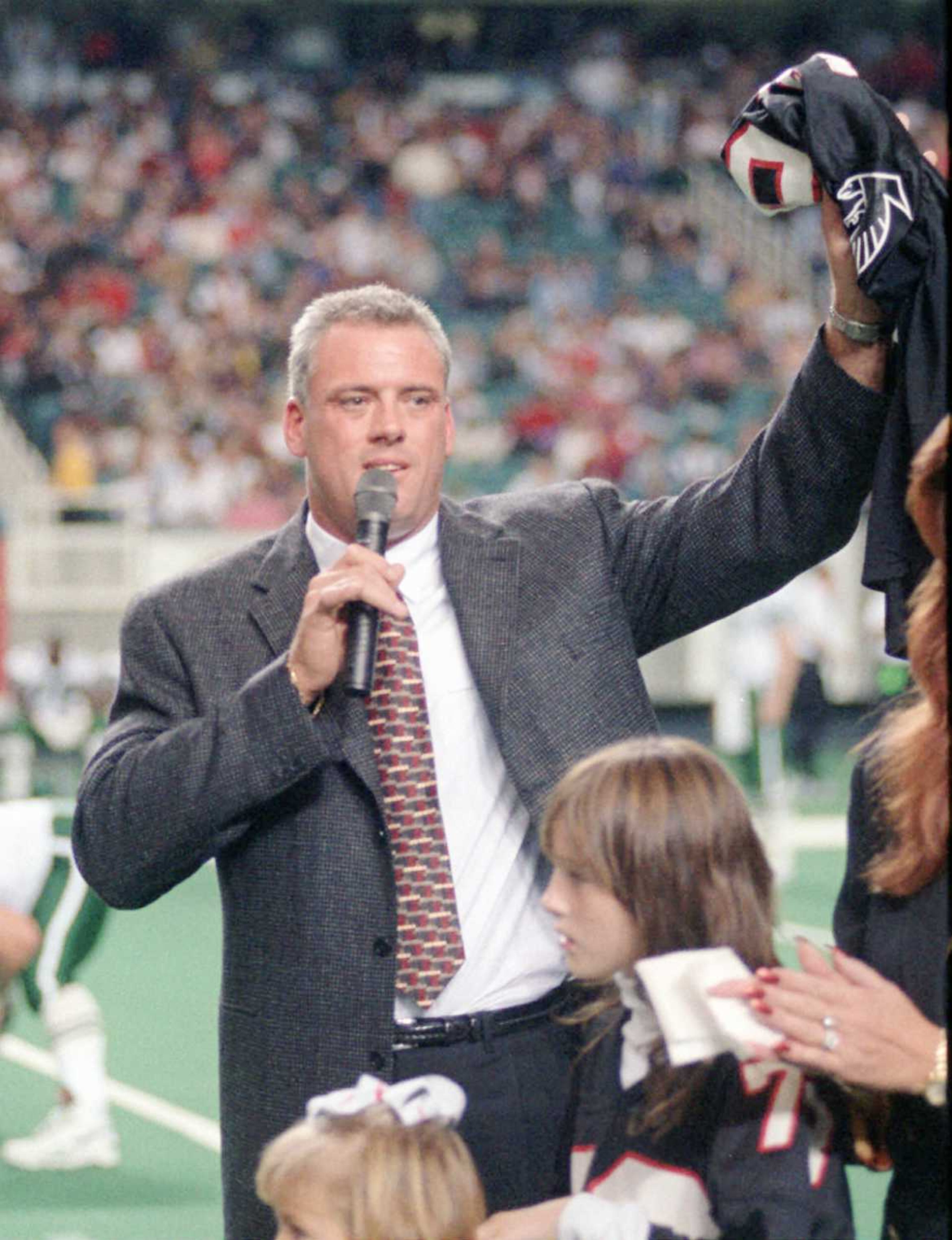 Mike Kenn waves to the crowd during halftime festivities honoring the long-time Falcon a year after he retired. AJC file photo
