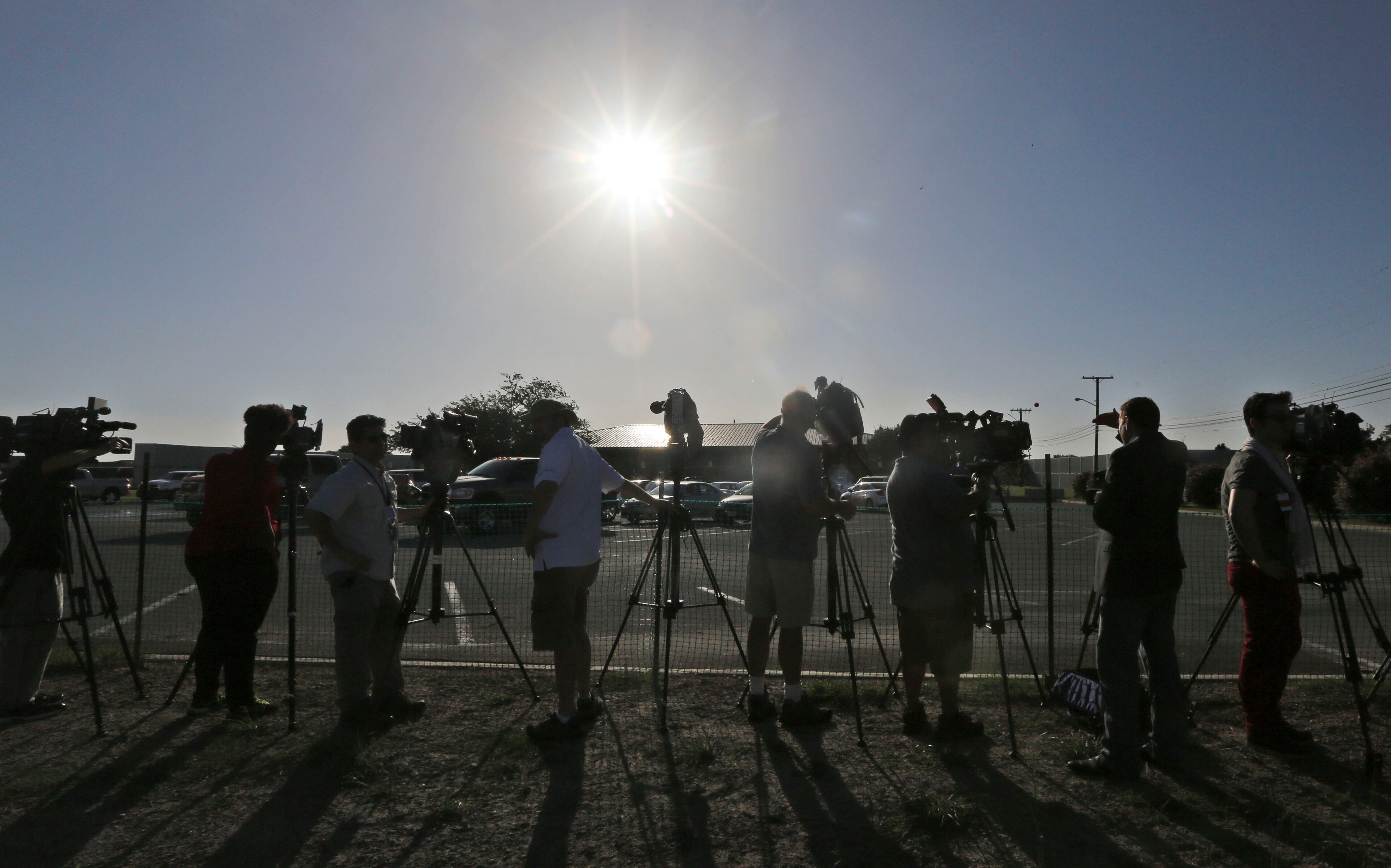 Media line up to take video and photos of the courthouse where the court-martial of Maj. Nidal Hasan is taking place Tuesday, Aug. 6, 2013, at Fort Hood. After years of delays, the trial of the man accused of carrying out the Fort Hood shooting is starting, with Hasan representing himself against charges of murder and attempted murder for the 2009 attack that left 13 people dead on the Army post.