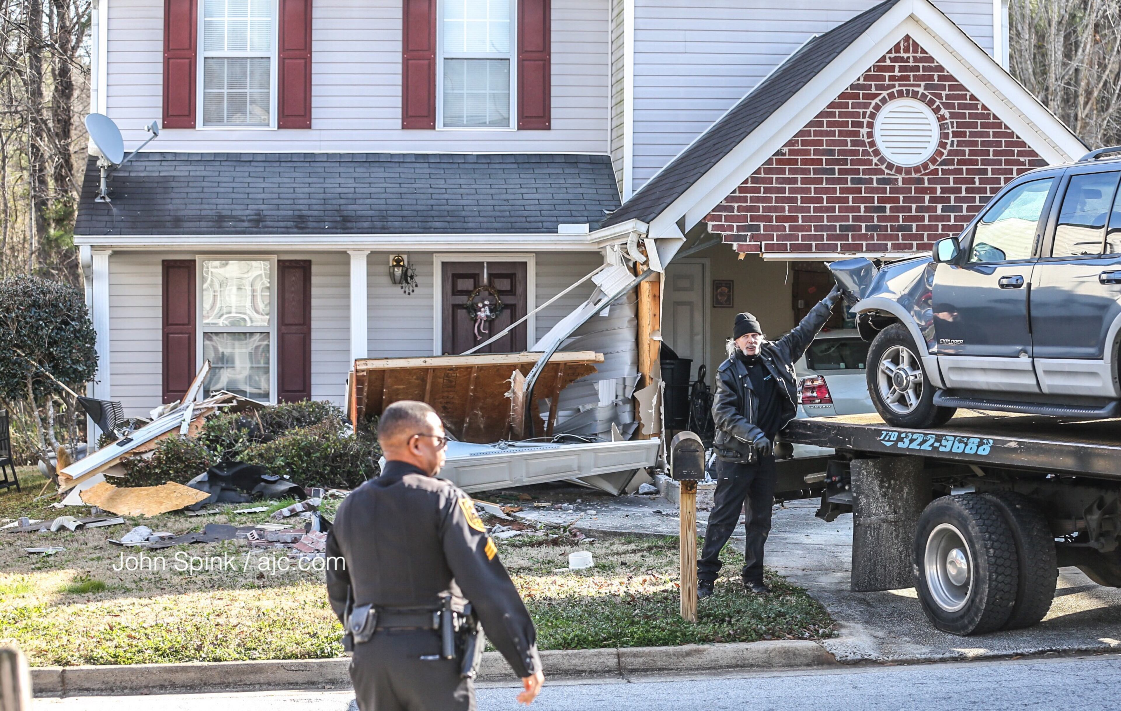 A stolen Ford SUV is towed away after it crashed Friday morning. JOHN SPINK / JSPINK@AJC.COM