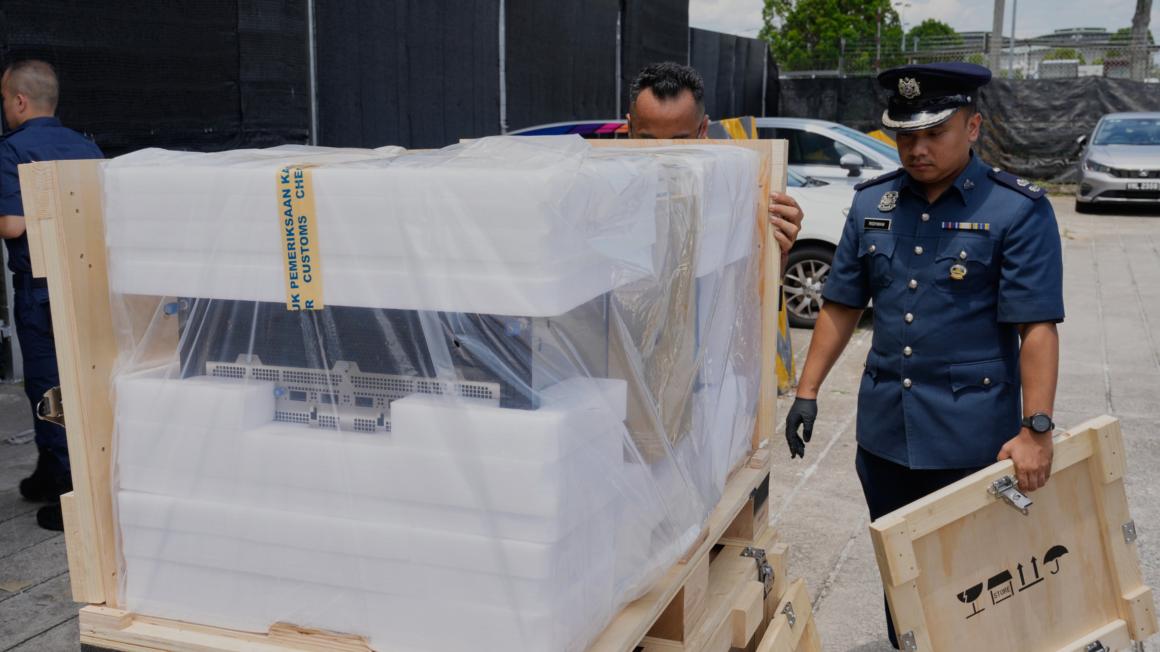 A Malaysian customs officer stands beside a seized server advanced containing artificial intelligence chips at its headquarters in Sepang, Malaysia, Wednesday, Oct. 28, 2026. (AP Photo/Vincent Thian)