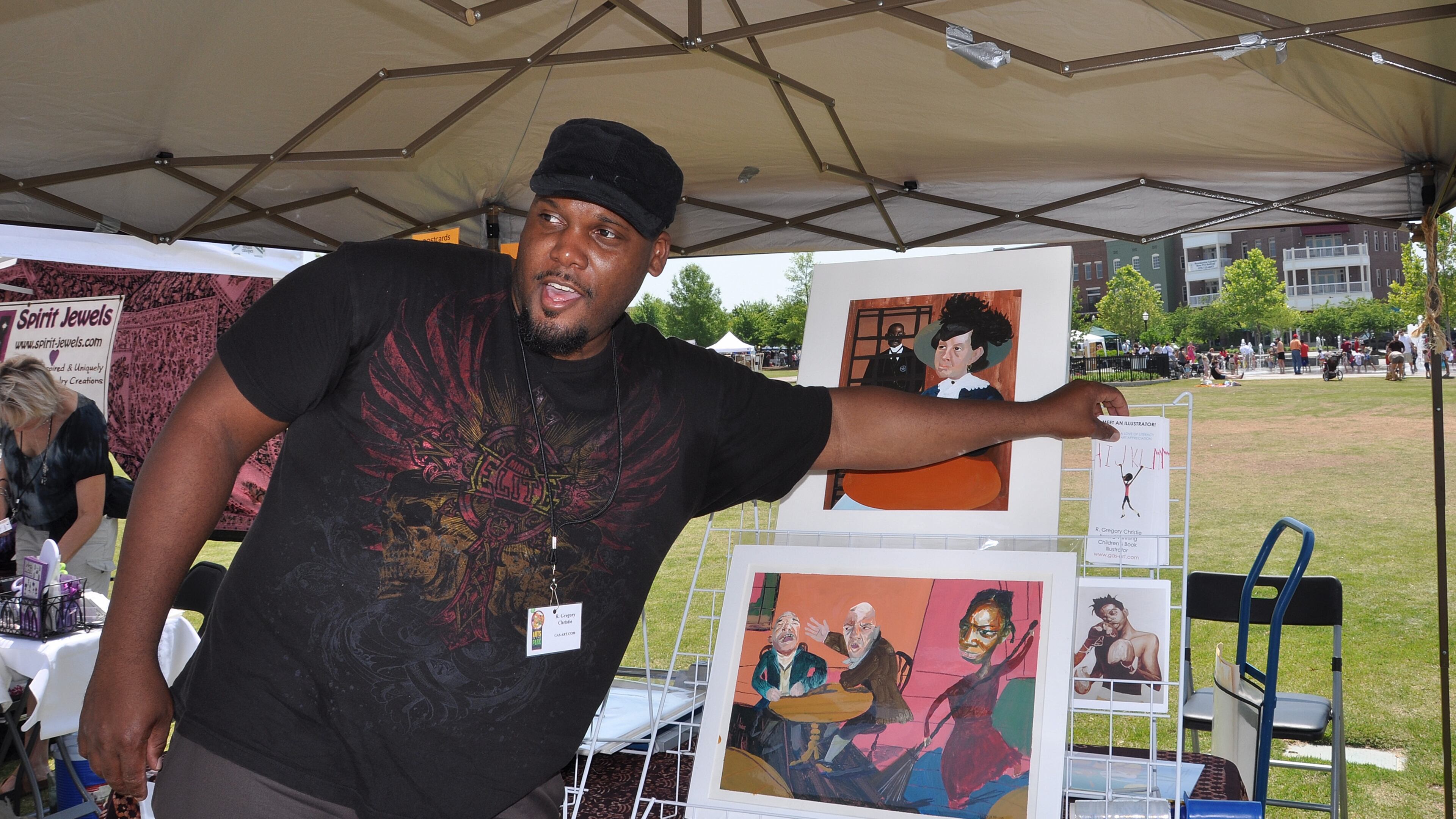 Artist and Illustrator R. Gregory Christie, of Mableton, distributes brochures about his art, children's books and website at Suwanee Town Center Park on May 21, 2011.