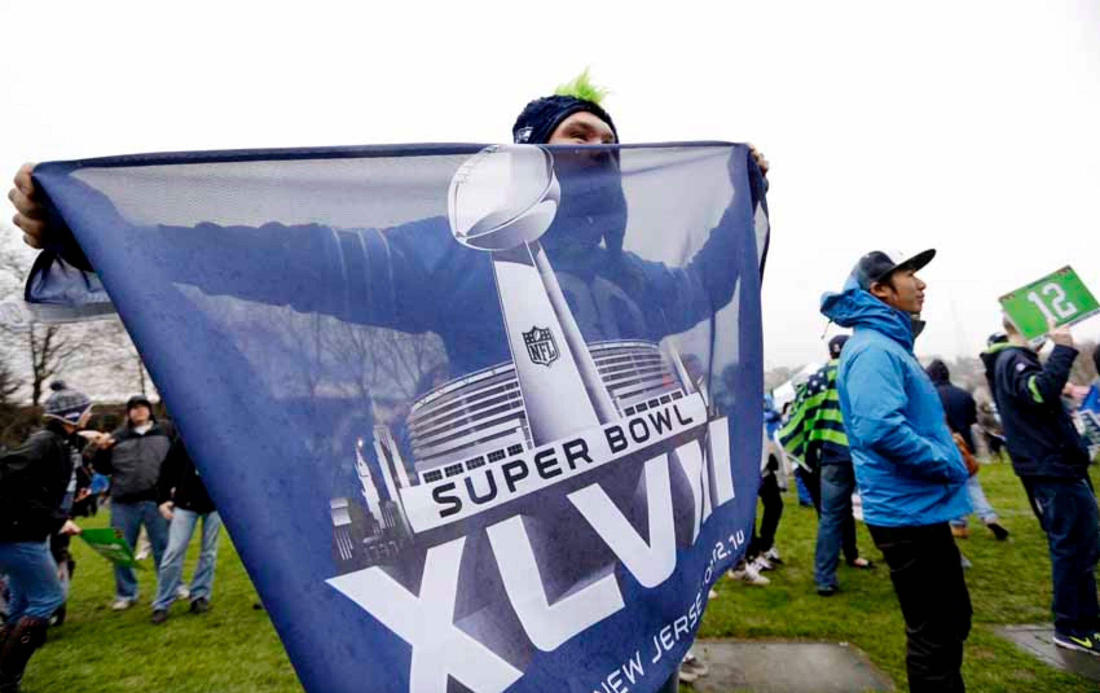 Alan Haines, of Marysville, Wash., holds a Super Bowl flag at a rally with other Seattle Seahawks fans near the Space Needle Wednesday, Jan. 29, 2014, in Seattle. The Seahawks play the Denver Broncos Sunday in Super Bowl XLVIII. (AP Photo/Elaine Thompson)