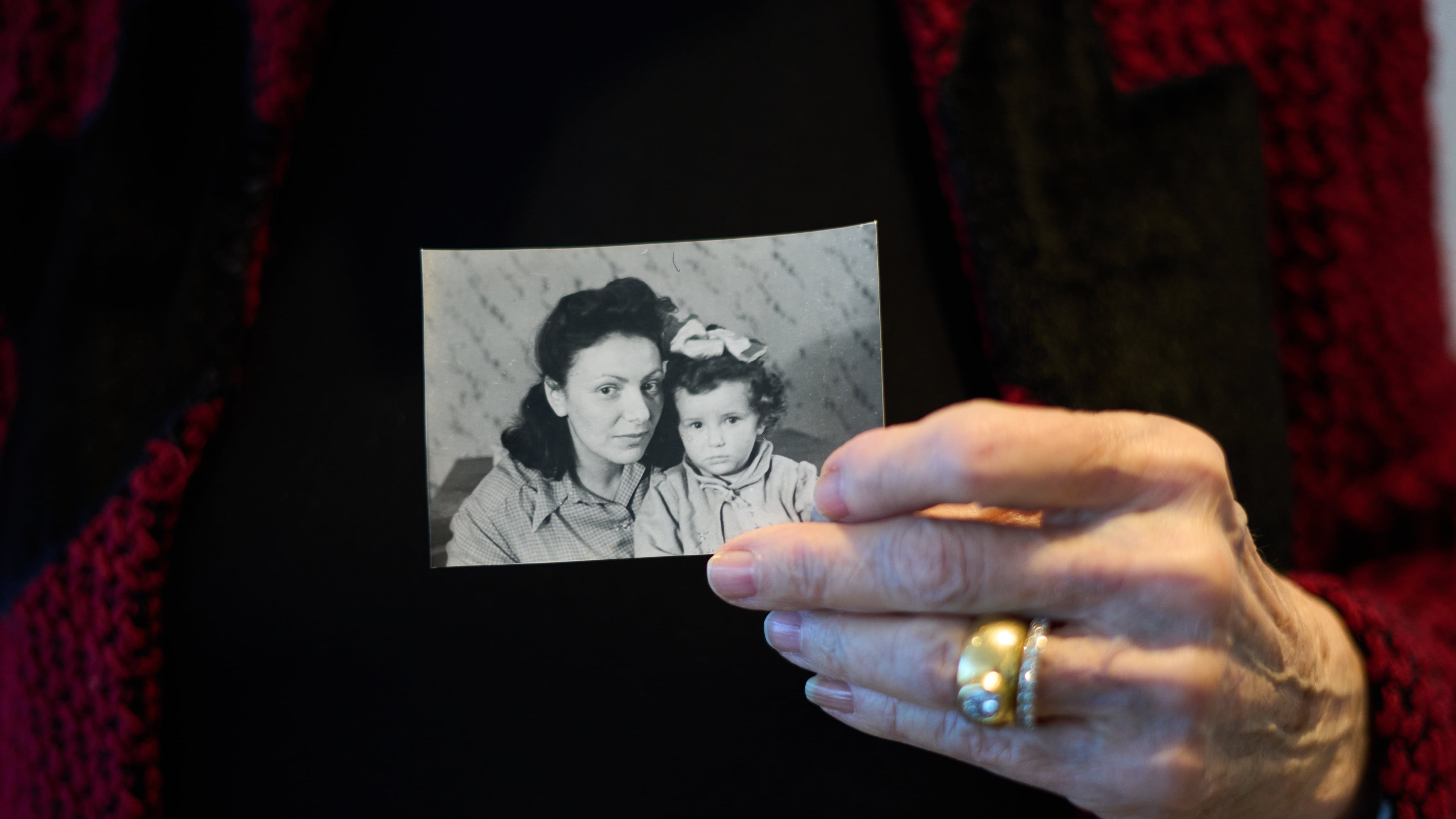 Holocaust survivor Ilana Shalem-Kantorowics born in the Nazi Bergen-Belsen concentration camp holds a photo of her with her mother Lola in the camp in 1946, in Tel Aviv, Israel, Jan. 26, 2026. (AP Photo/Ariel Schalit)