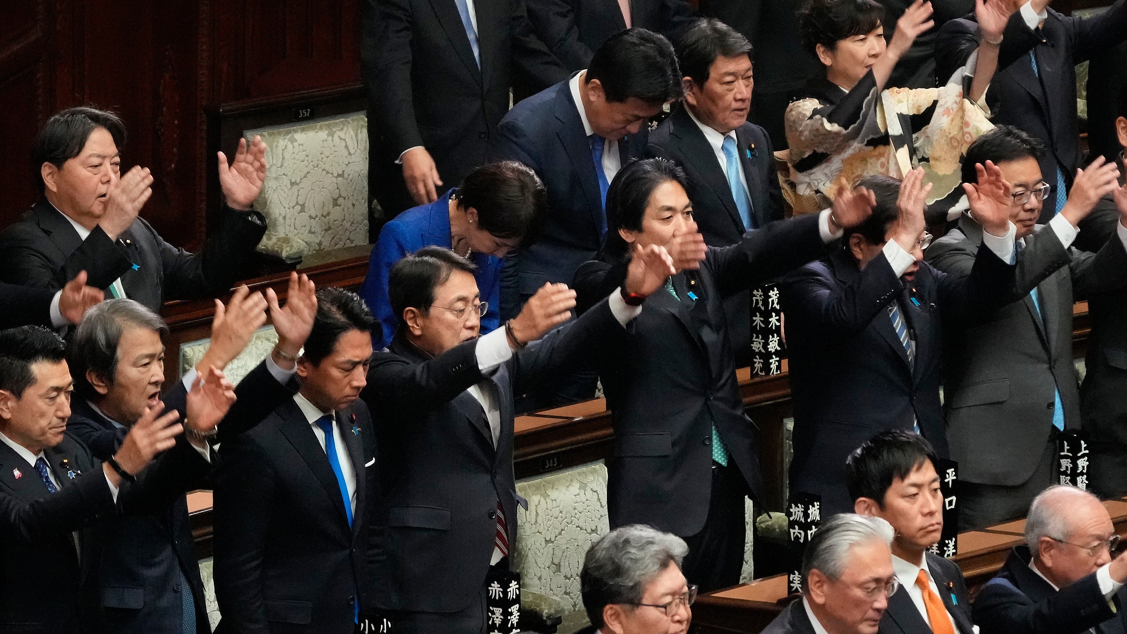 Japanese Prime Minister Sanae Takaichi, center in blue jacket, bows and other lawmakers cheer after dissolving the lower house, during an extraordinary Diet session at the lower house of parliament Friday, Jan. 23, 2026, in Tokyo. (AP Photo/Eugene Hoshiko)