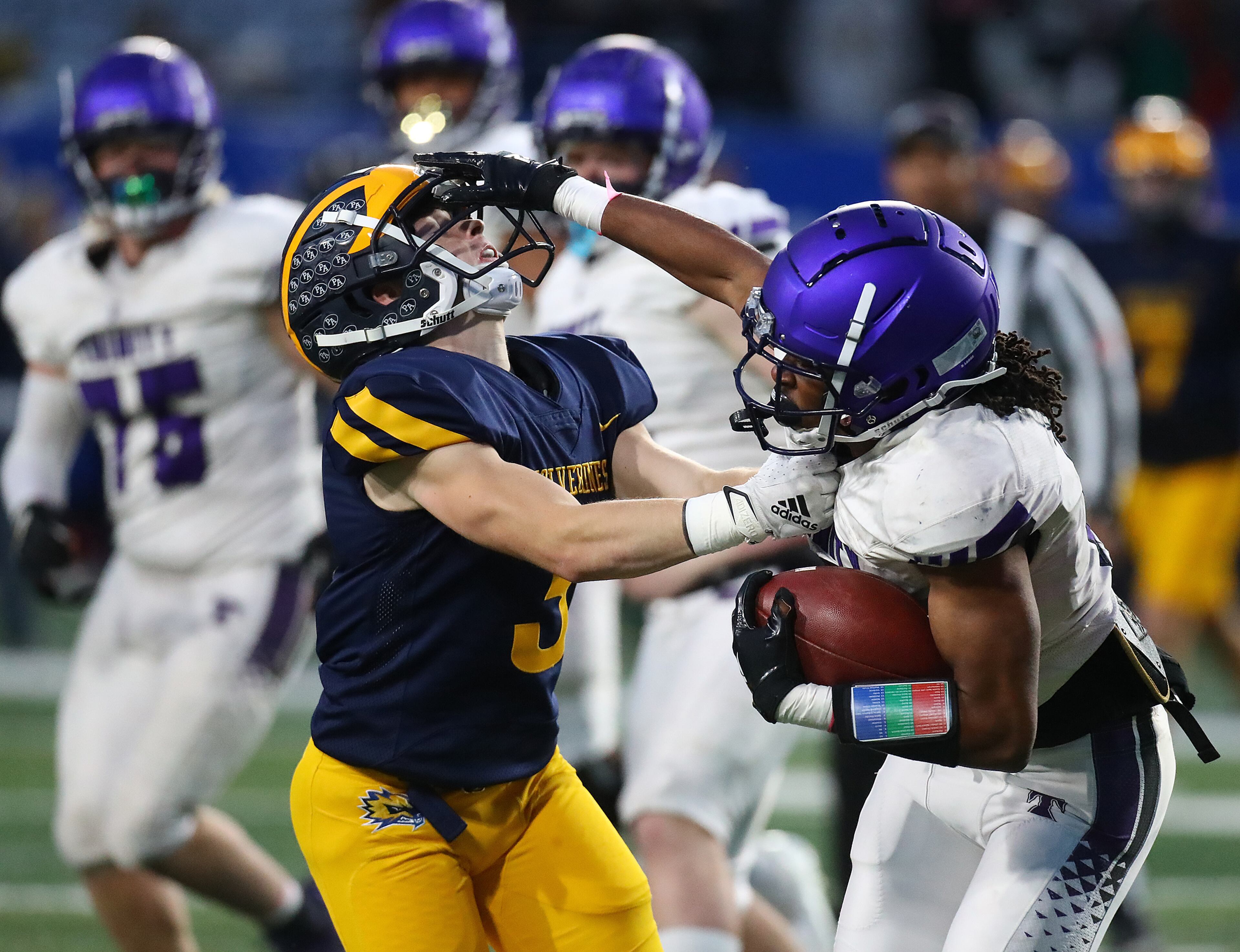 Trinity Christian running back Dominick Cosper fends off Prince Avenue Christian defensive back Will Elrod with a stiff arm for extra yardage during the first quarter in their GHSA Class A Private Championship game on Thursday, Dec 9, 2021, in Atlanta. “Curtis Compton / Curtis.Compton@ajc.com”`
