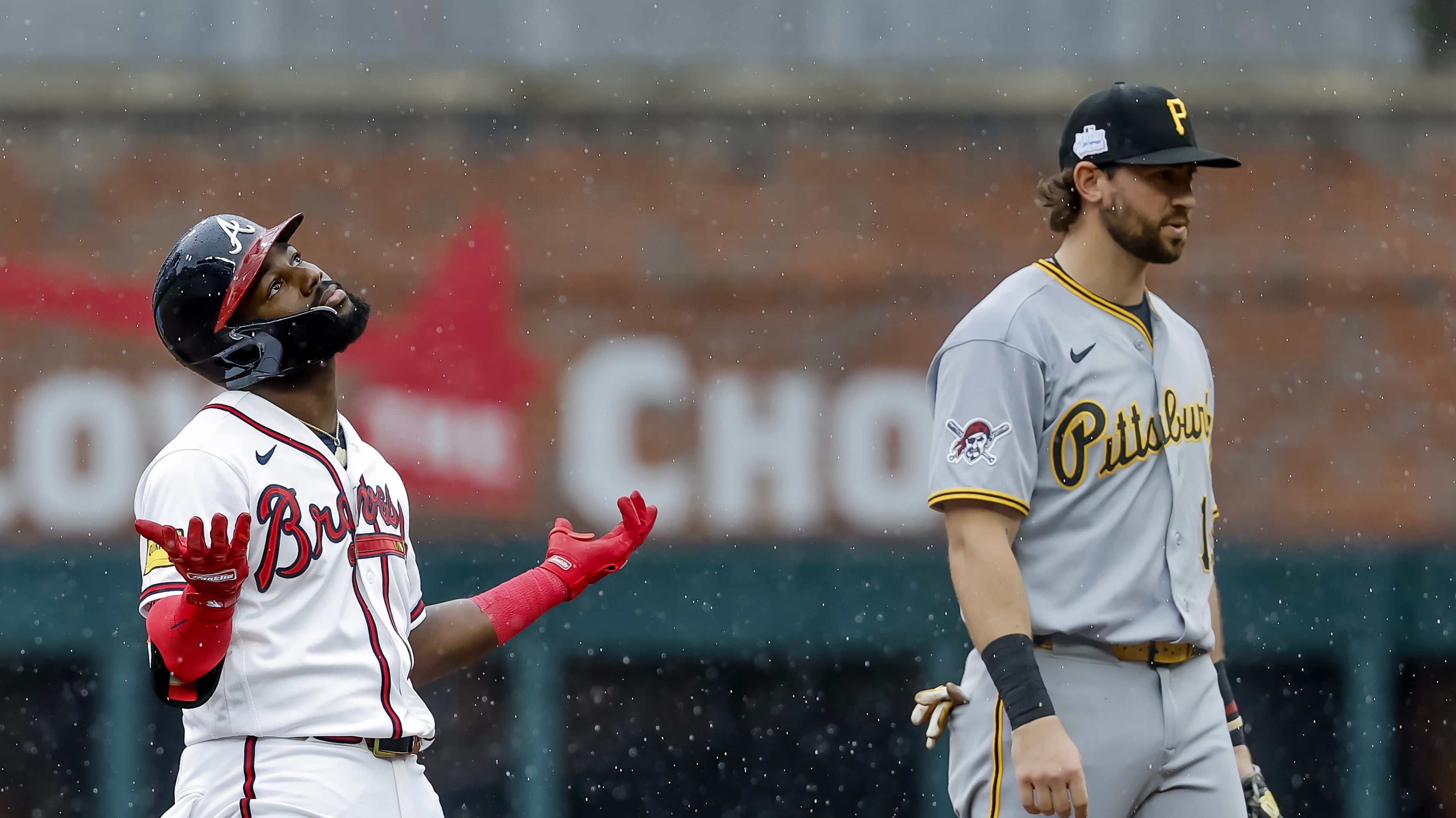 Atlanta Braves pinch hitter Michael Harris II, left, reacts after hitting a three-run double as Pittsburgh Pirates shortstop Jared Triolo, right, looks on during the seventh inning of a baseball game, Sunday, June 7, 2026, in Atlanta. (AP Photo/Erik S. Lesser)