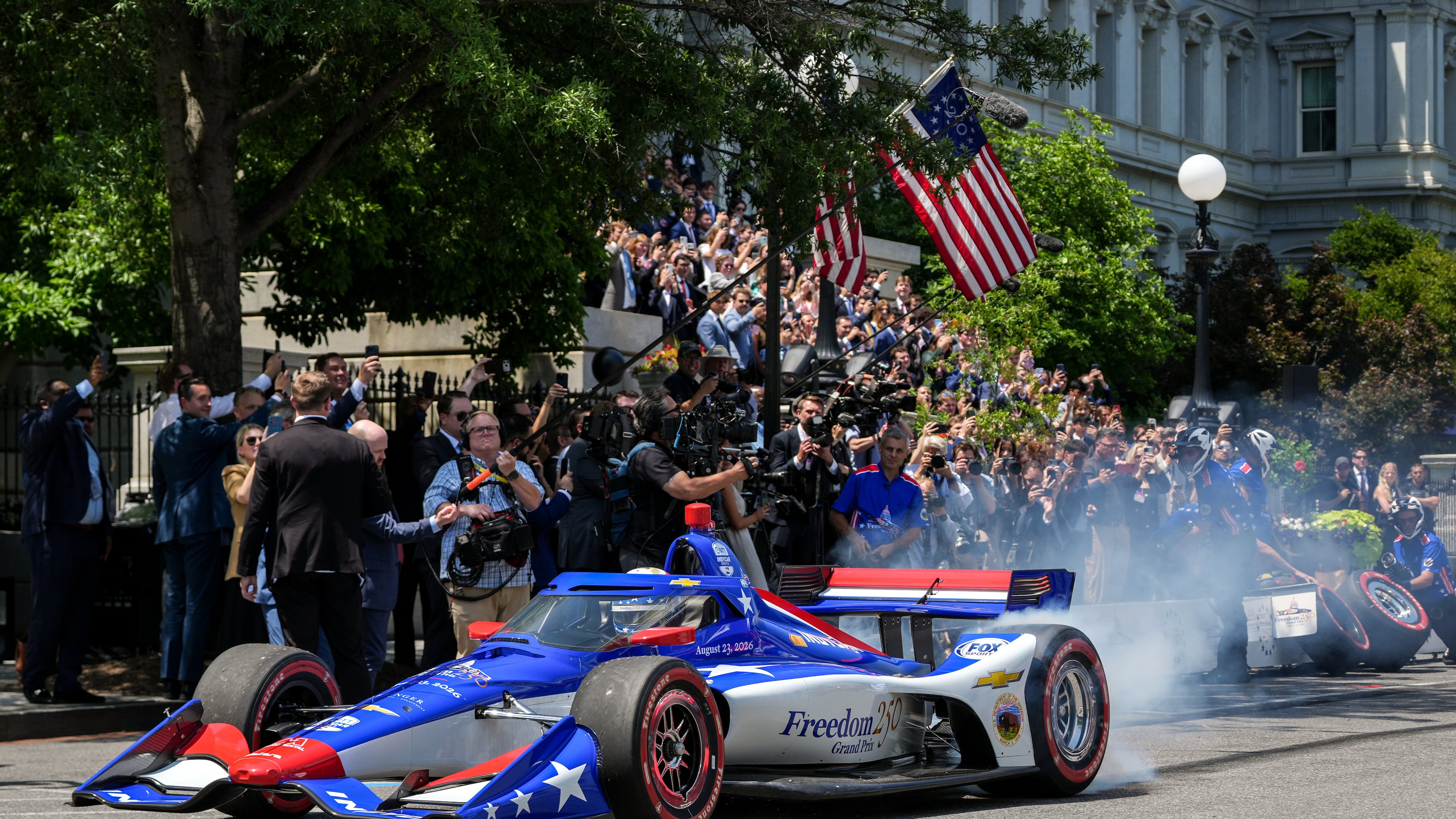 IndyCar Series driver David Malukas drives a race car down West Executive Drive during an event with President Donald Trump to promote the upcoming Freedom 250 Grand Prix auto race, Monday, July 13, 2026, at the White House in Washington. (AP Photo/Julia Demaree Nikhinson)