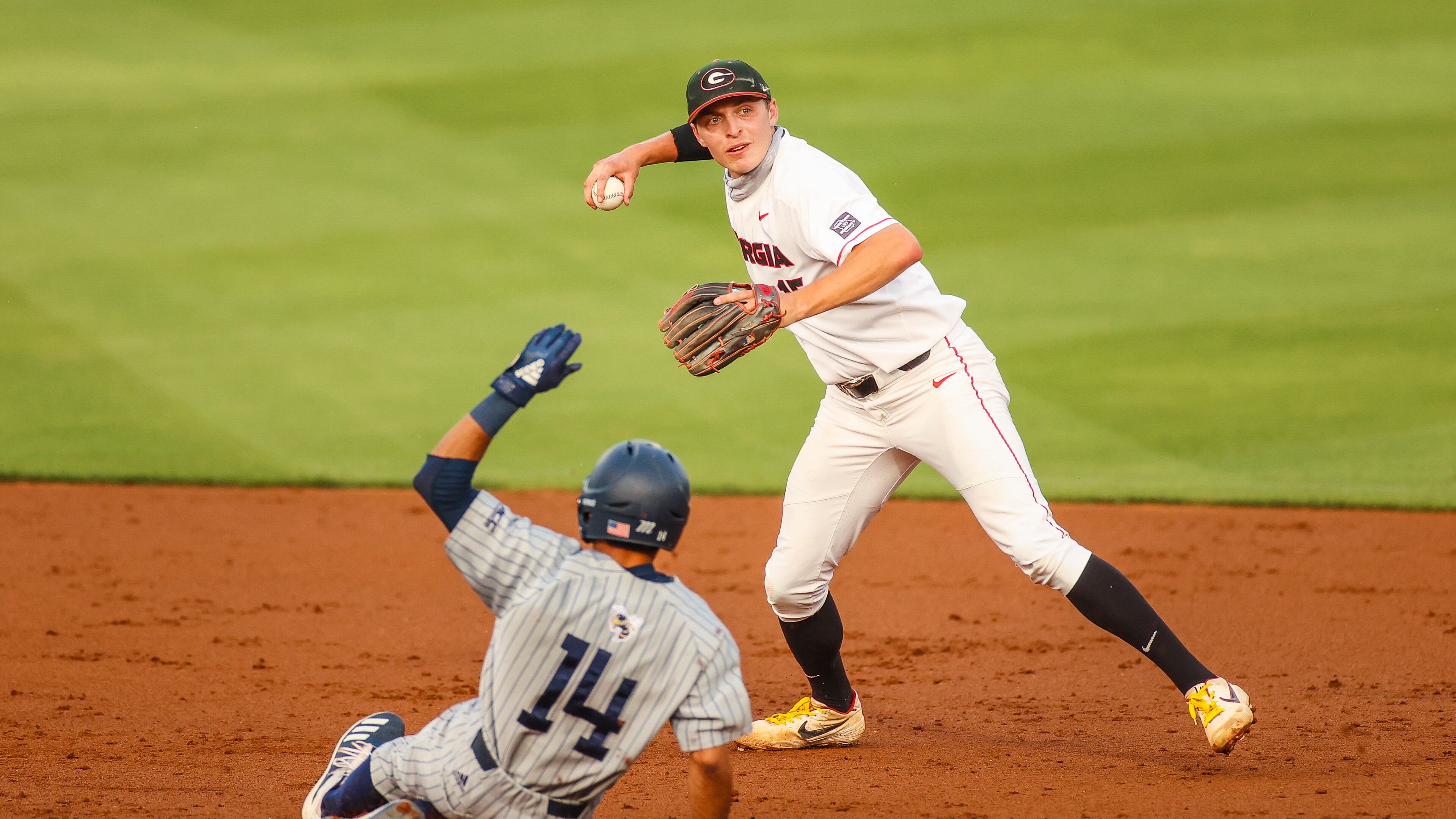 Georgia shortstop Cole Tate (15) gets the first out in an attempted double play as Georgia Tech's Austin Wilhite slides nto second base at Foley Field in Athens on Tuesday, April 27, 2021. (Photo by Tony Walsh/UGA Athletics)