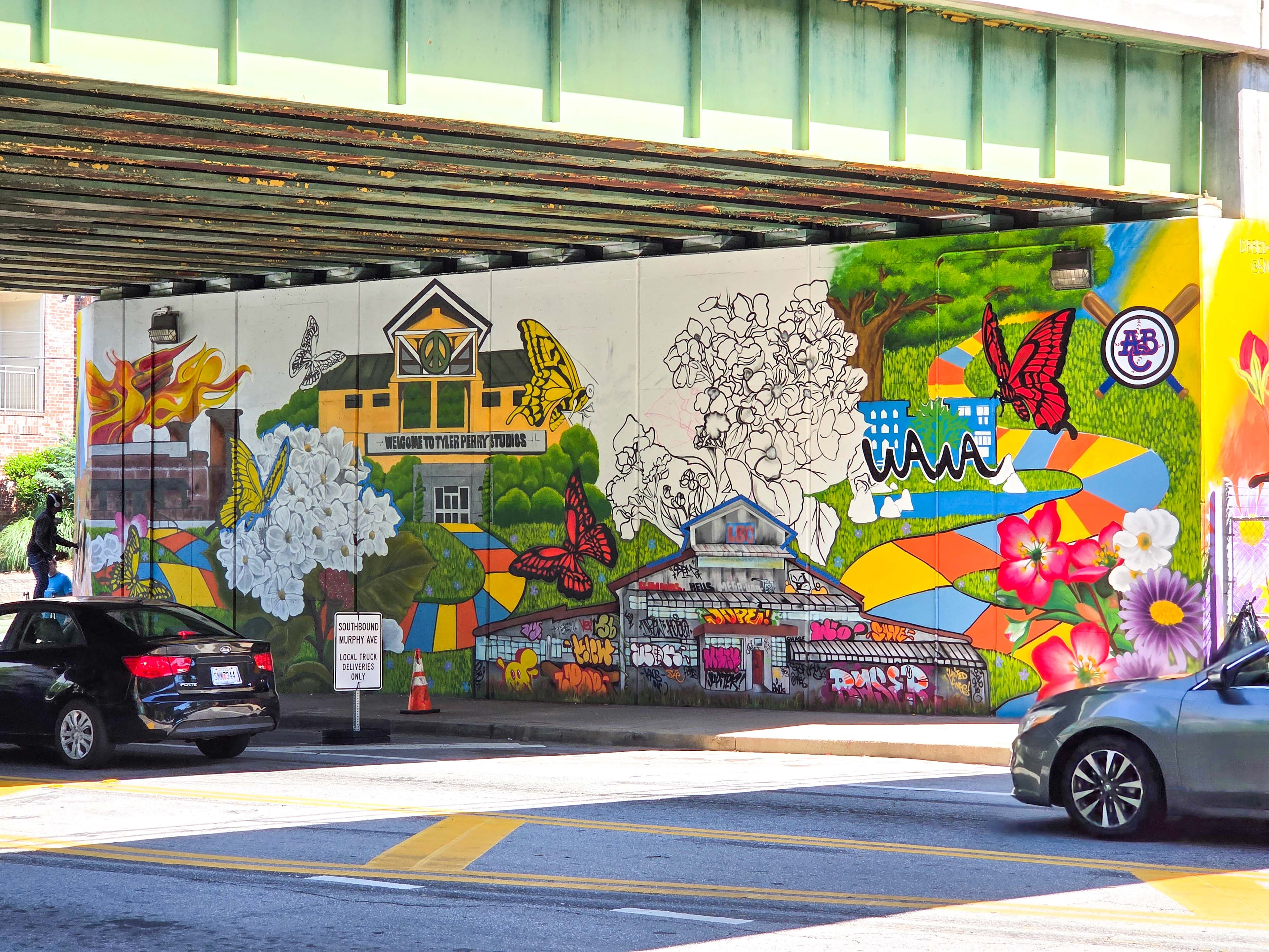 Debbi Snax’s untitled mural is captured in progress. It celebrates the resilience of neighborhoods in Atlanta City Council District 12. (Courtesy of Arthur Rudick)