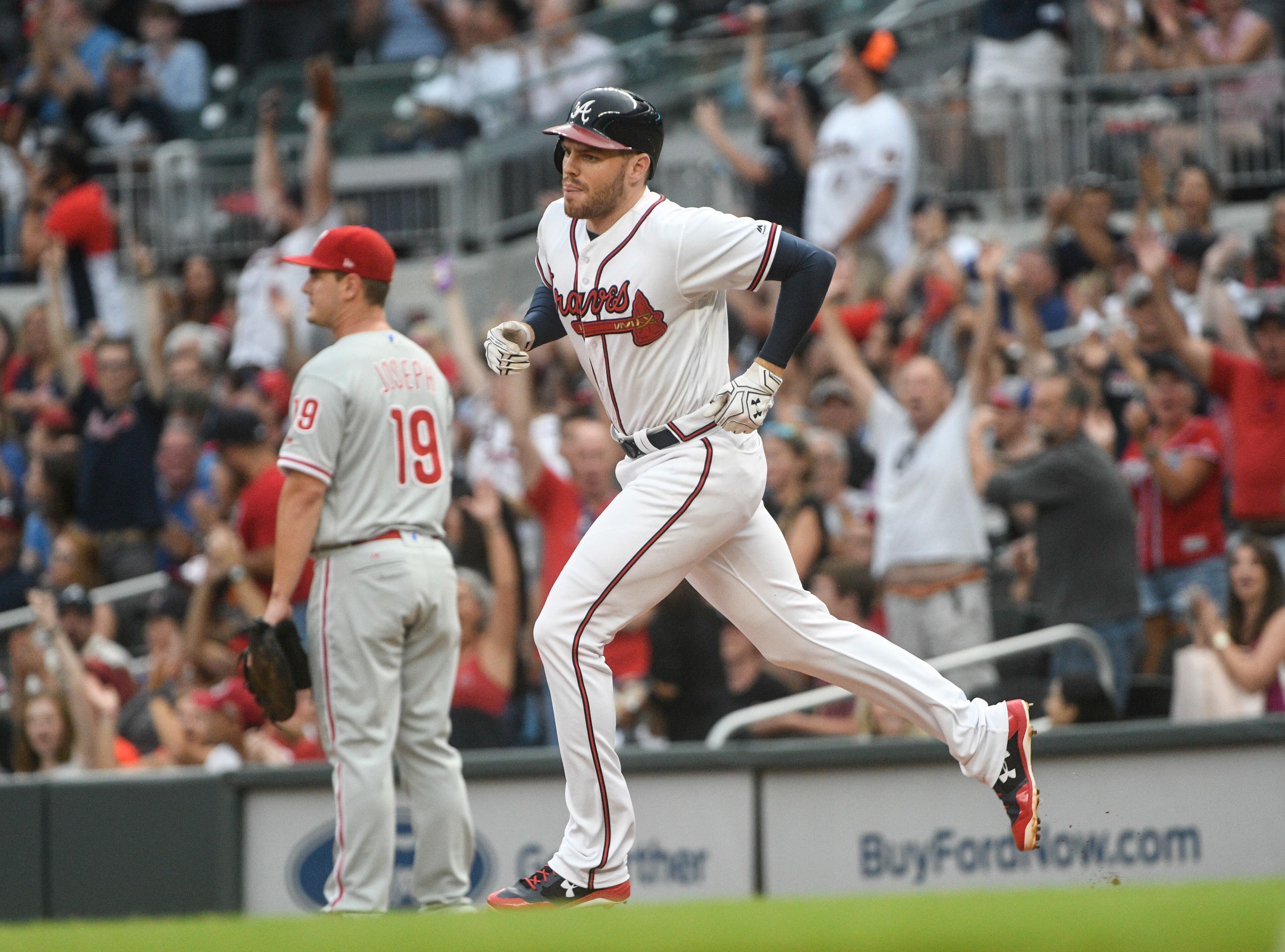 Atlanta Braves' Freddie Freeman passes Philadelphia Phillies first baseman Tommy Joseph (19) as he runs the bases after he hit a home run in the first inning of a baseball game, Tuesday, Aug. 8, 2017, in Atlanta. (AP Photo/John Amis)