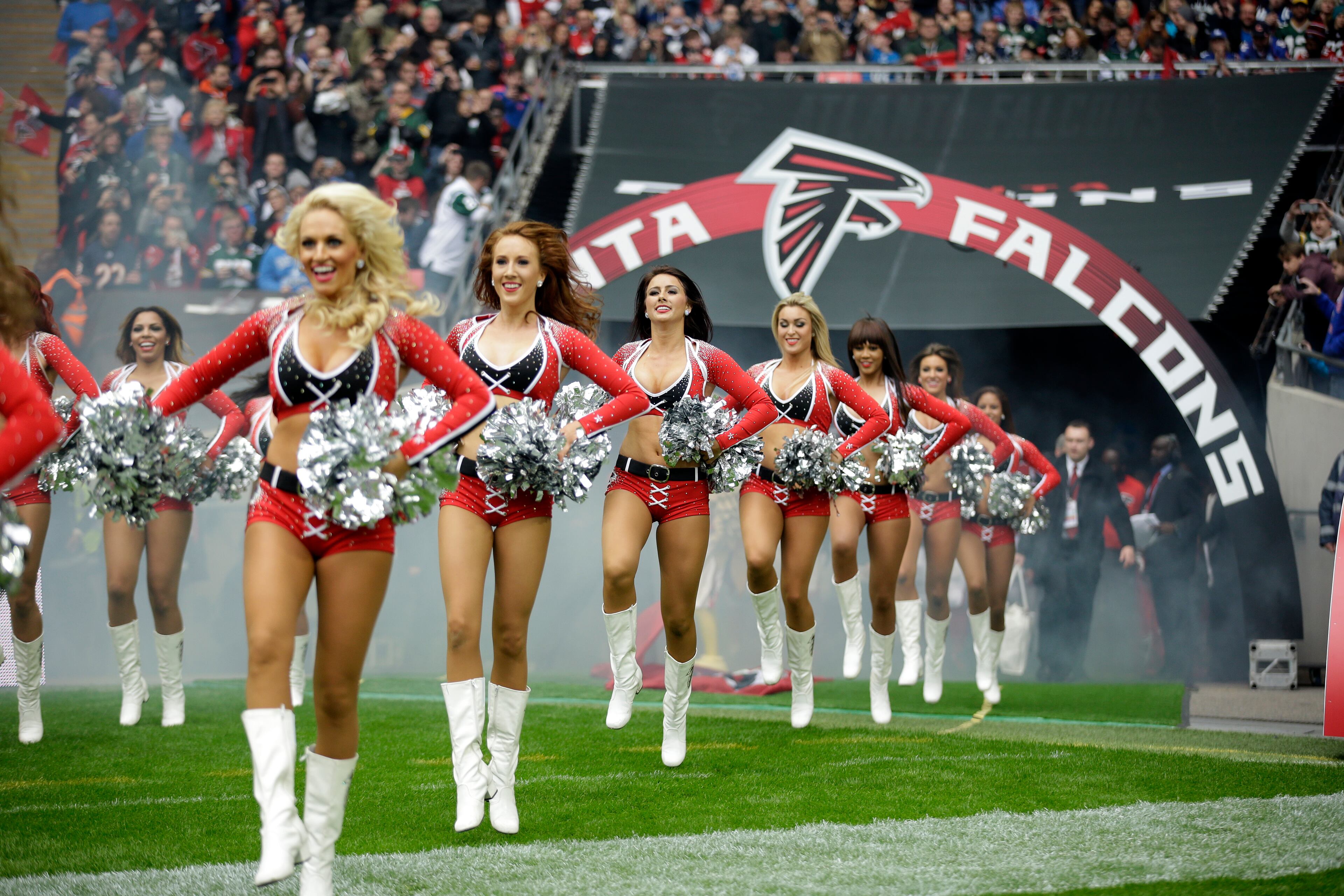 Atlanta Falcons cheerleaders run to the field before the NFL football game between the Atlanta Falcons and the Detroit Lions at Wembley Stadium, London, Sunday, Oct. 26, 2014. (AP Photo/Matt Dunham)