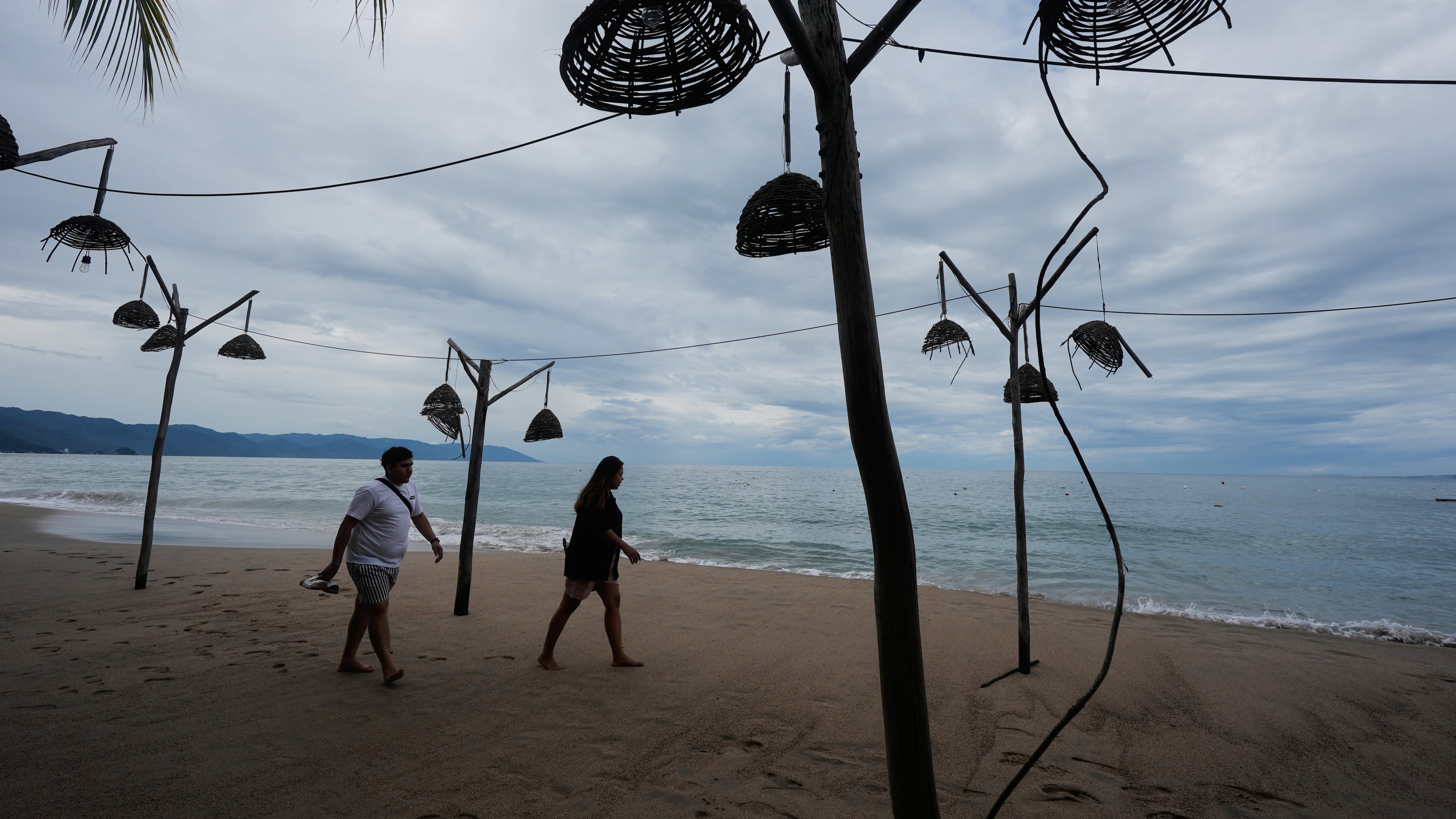 People walk on the beach after the passing of Hurricane Simon in Puerto Vallarta, Mexico, Monday, Oct. 12, 2026. (AP Photo/Fernando Llano)