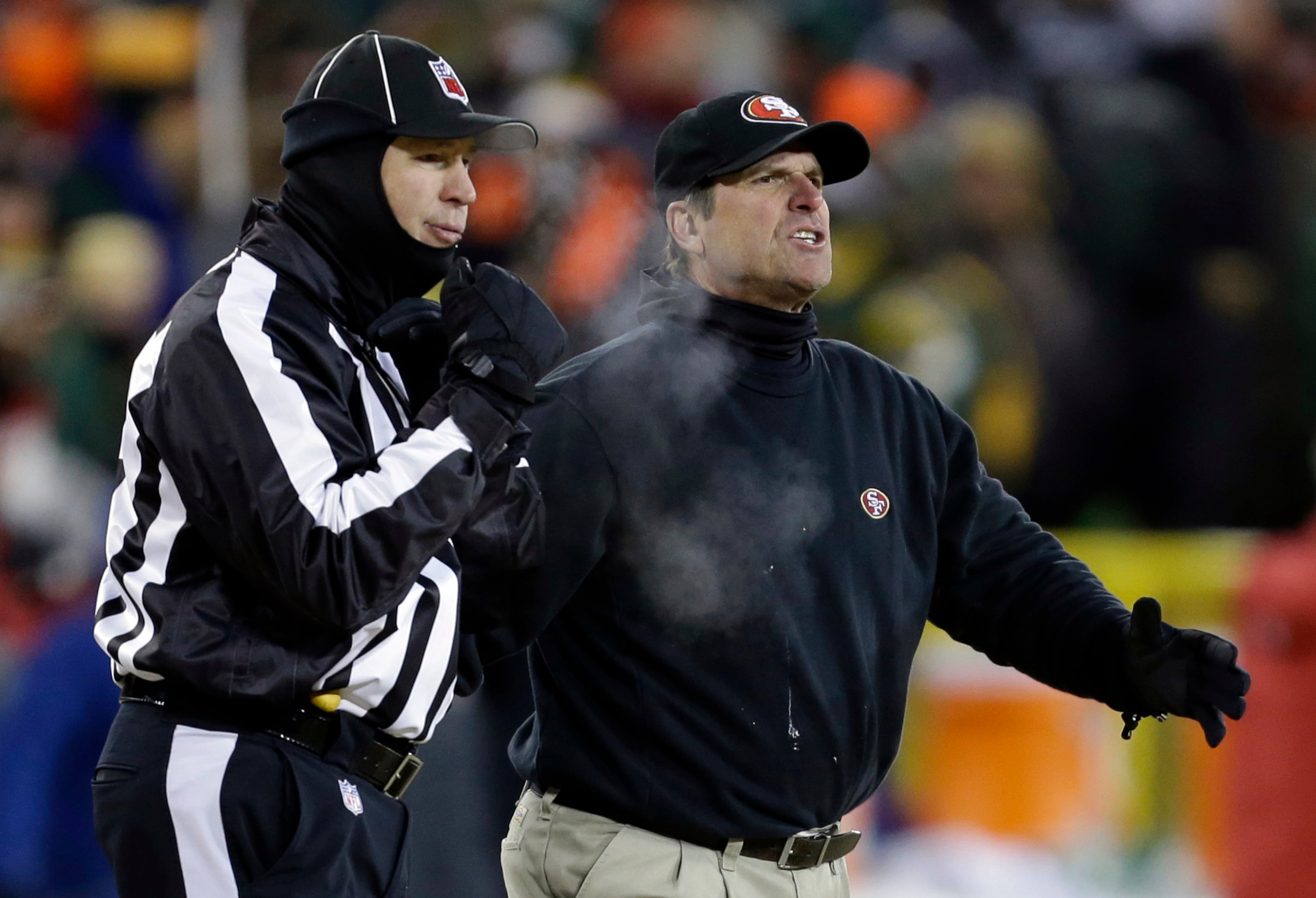 San Francisco 49ers head coach Jim Harbaugh argues a call with an official during the first half of an NFL wild-card playoff football game against the Green Bay Packers, Sunday, Jan. 5, 2014, in Green Bay, Wis.