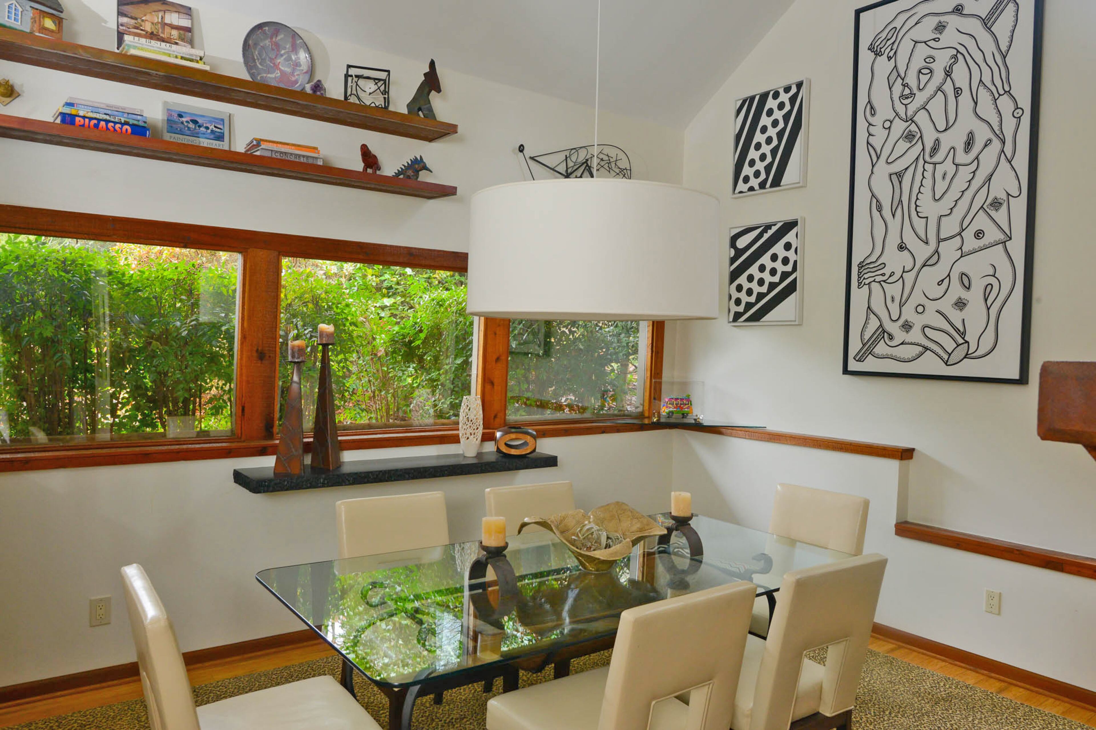 The dining room is an entertainment hub for Thomas Drew and Barbara Morrison. The high ceilings give the room an open feeling, while also leaving room for the black-and-white work of Mac Stewart to be displayed.