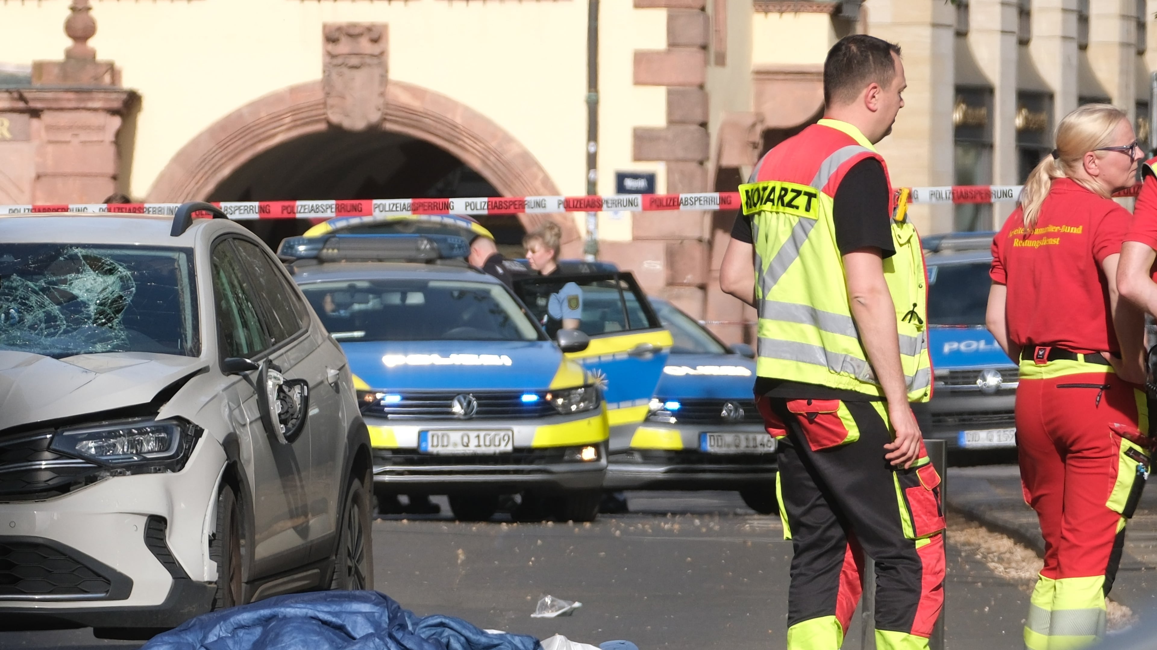Rescue workers stand next to a damaged car that has crashed into several people in Leipzig, Germany, Monday, May 4, 2026. (Sebastian Willnow/dpa via AP)