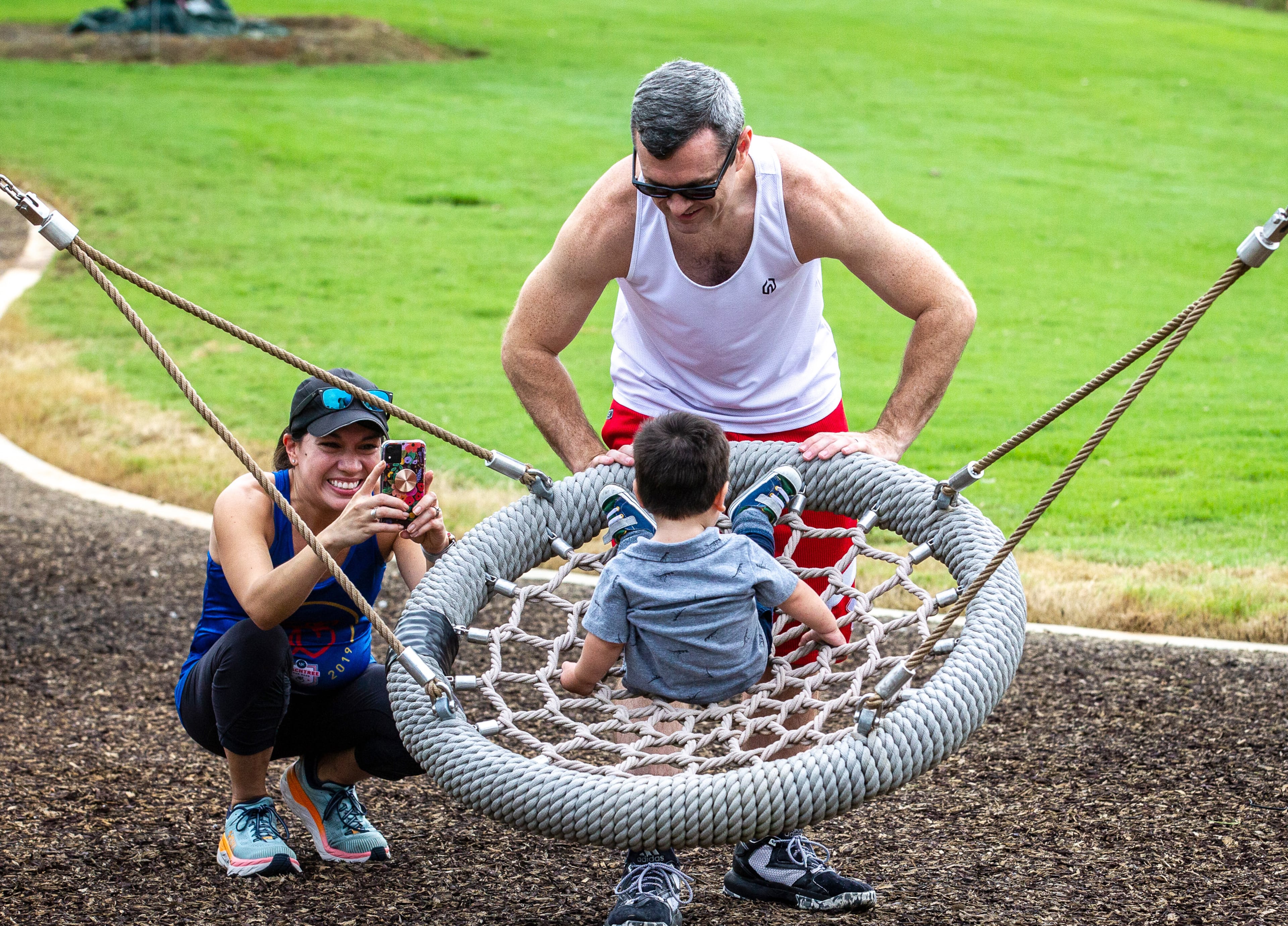 Jason Rawson pushes his son Miles on one of the swings as his wife Ana takes a photograph after the public opening of Atlanta's largest planned greenspace, the Westside Park, Friday, August 20, 2021. STEVE SCHAEFER FOR THE ATLANTA JOURNAL-CONSTITUTION