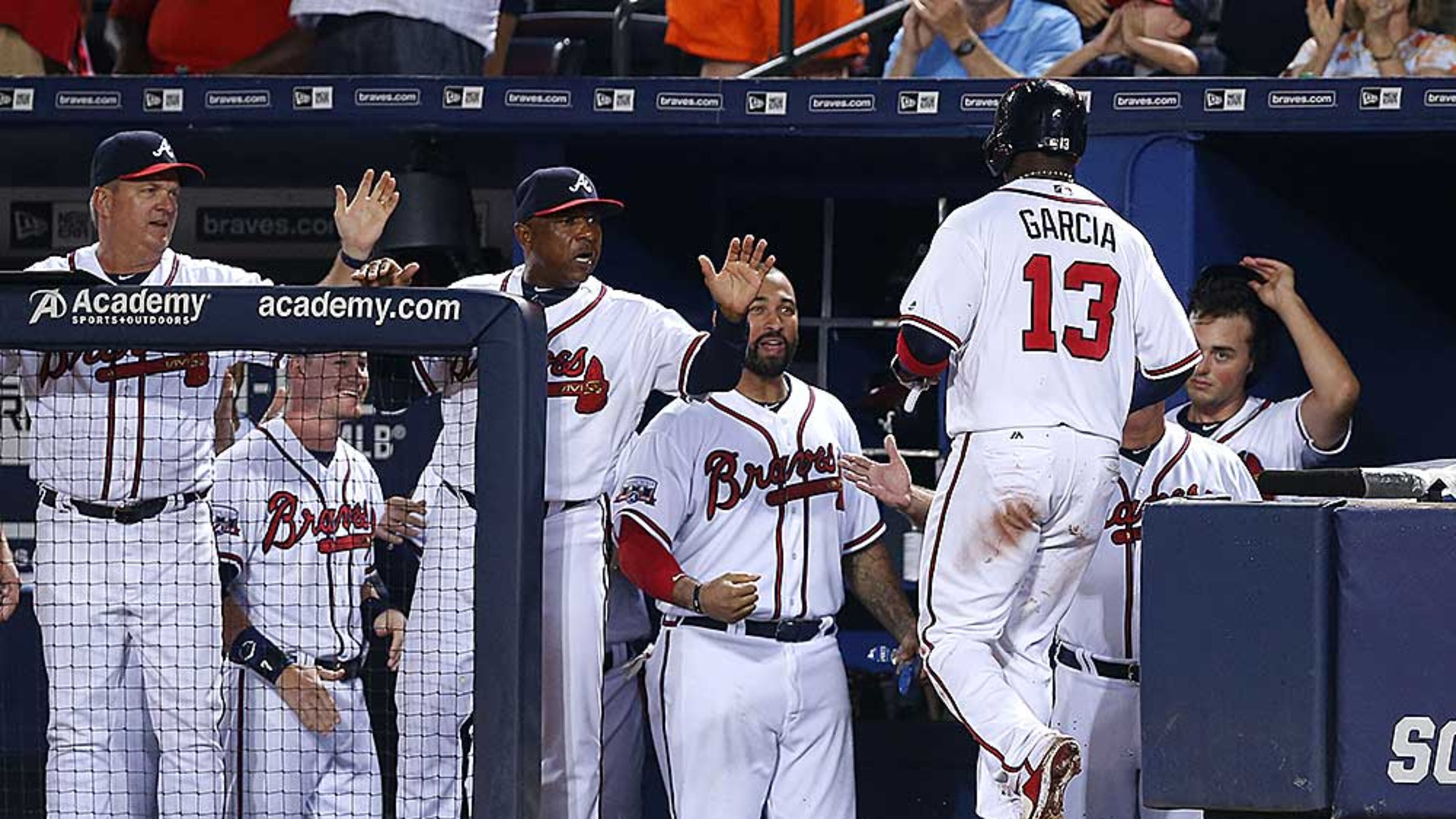 Adonis Garcia is congratulated in the dugout after scoring in the seventh inning of Thursday's game.