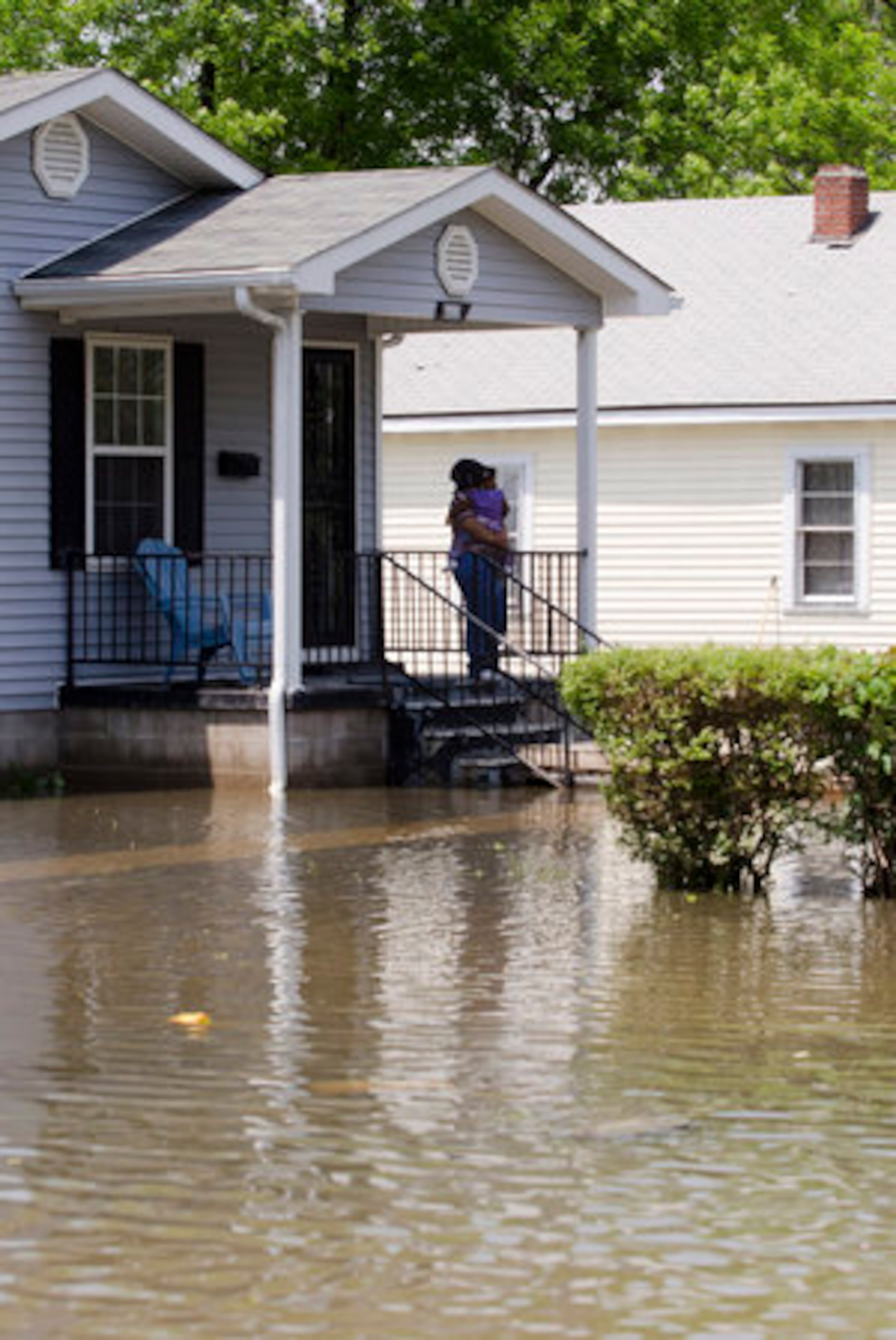Pam Young stands on her front porch holding her granddaughter, 18 month old Alex Boyd in her arms as she looks at all the water around her home on Saturday May 7, 2011 on the north end of Tiptonville, Tenn. Young left her home for two days because of flood waters from the Mississippi.
