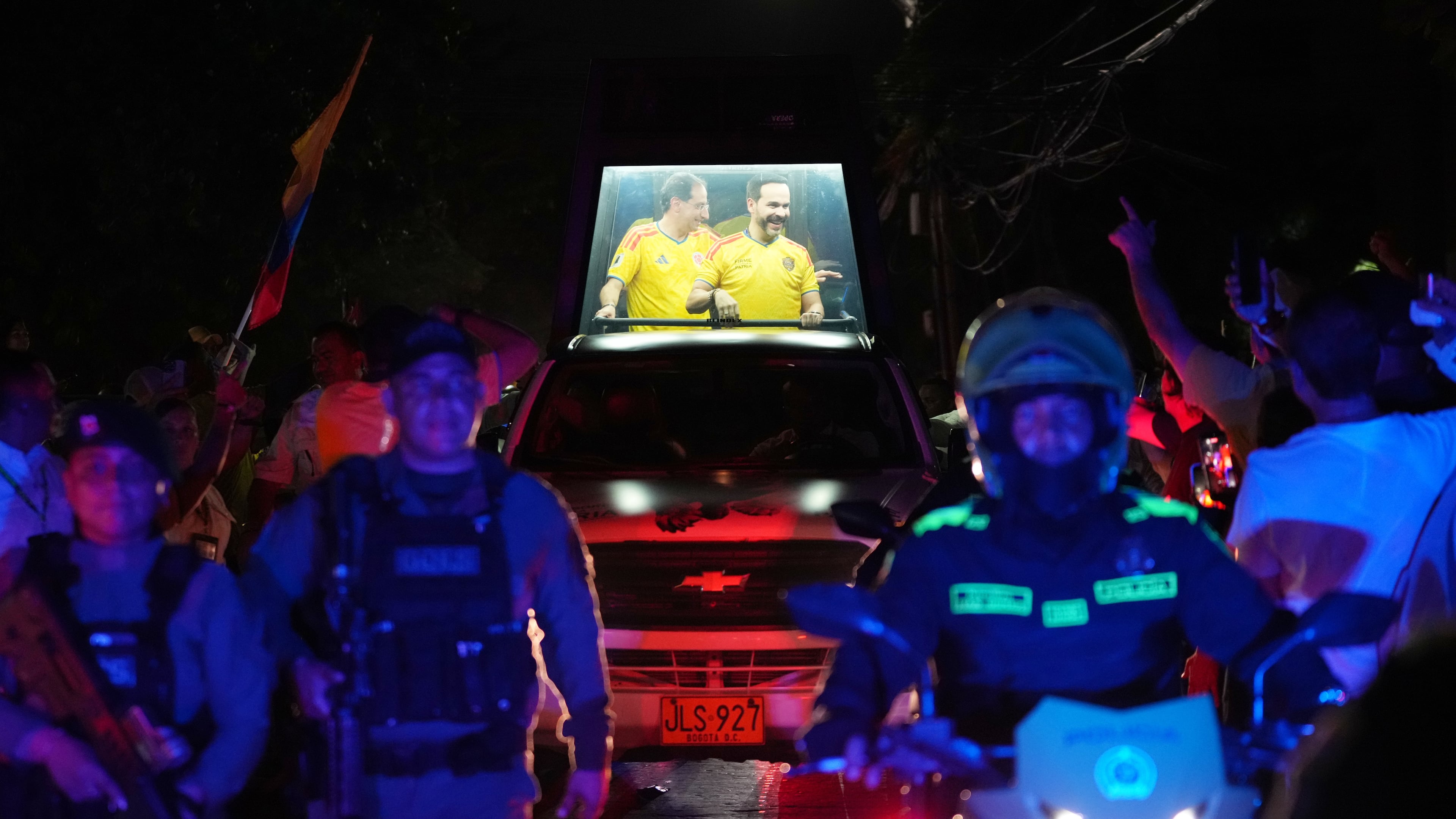 Presidential candidate Abelardo de la Espriella of the opposition Defenders of the Motherland movement and his vice-presidential running mate, Jose Manuel Restrepo, ride in a bulletproof booth toward a celebration rally after election results showed him leading in Barranquilla, Colombia, Sunday, June 21, 2026. (AP Photo/Rodrigo Abd)