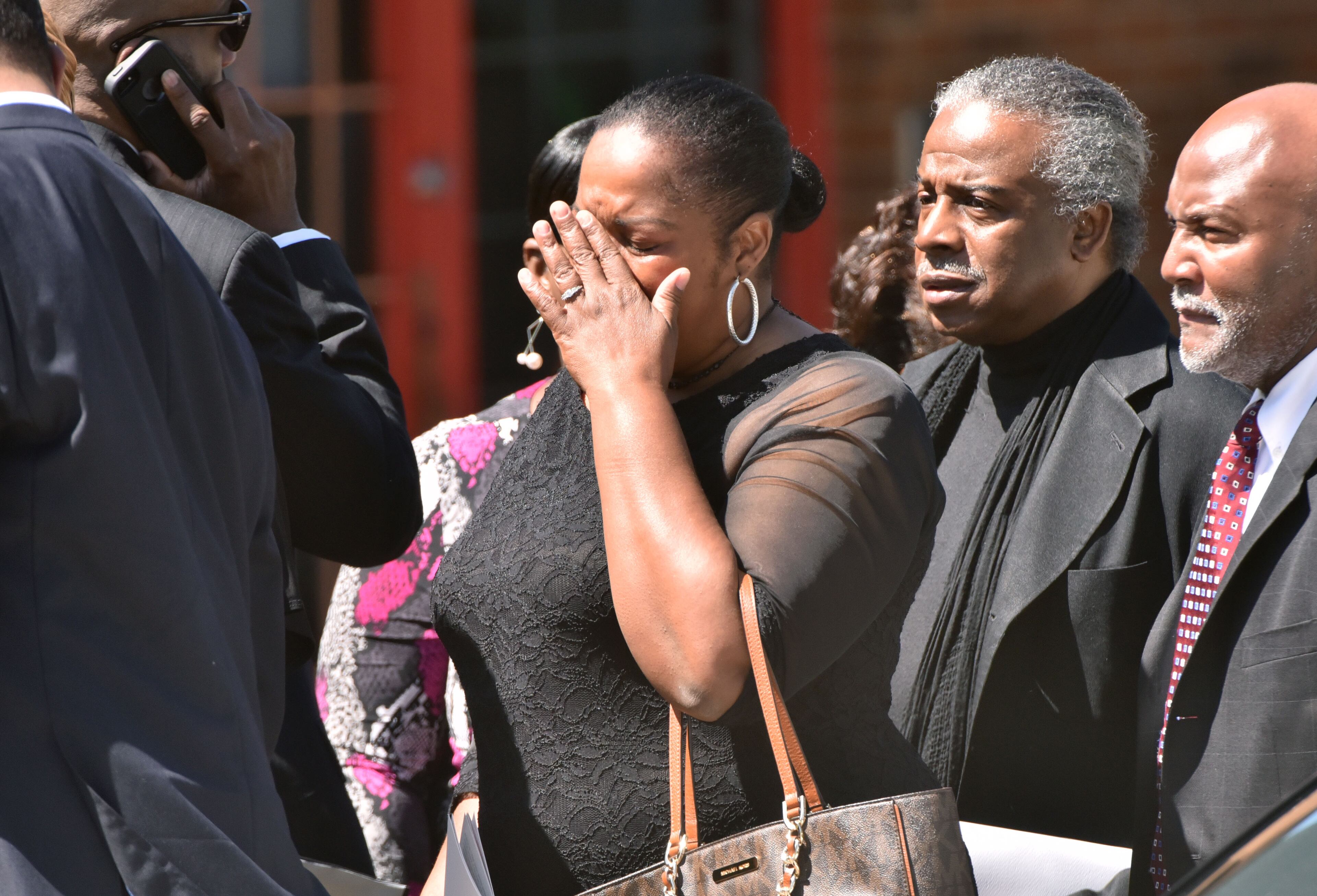 A mourner can't hide her emotion as she waits to enter Antioch Baptist Church North for the funeral service of community leader Barney Simms on Saturday, April 16, 2016. HYOSUB SHIN / HSHIN@AJC.COM