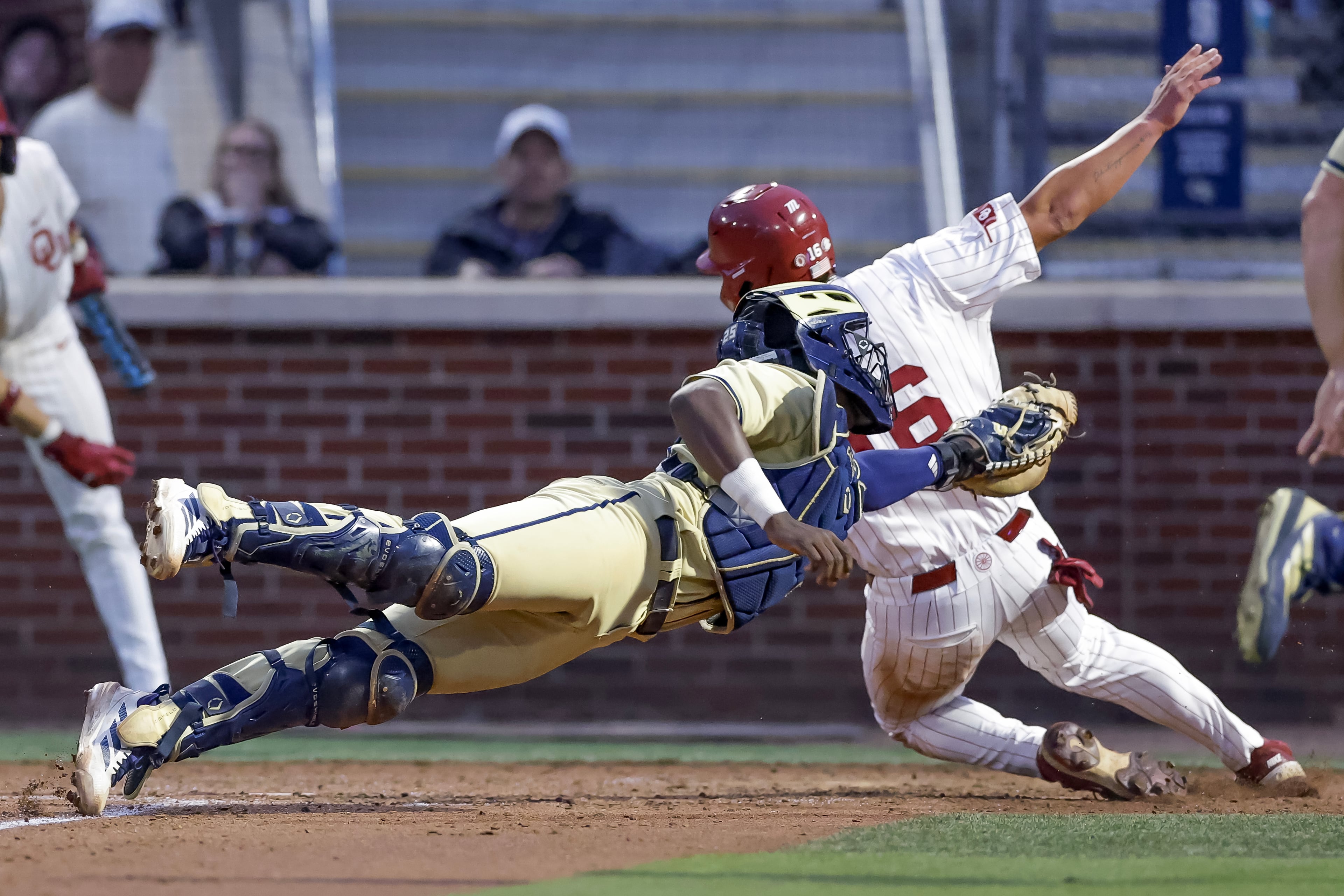 Georgia Tech catcher Vahn Lackey, left, tags out OklahomaÕs Dayton Tockey (16) during the fifth inning of the Atlanta Regional game at Russ Chandler Stadium, Sunday, May 31, 2026, in Atlanta. The Yellow Jackets lost to the Sooners and will have to play on Monday, June 1. (Erik S. Lesser for the AJC)