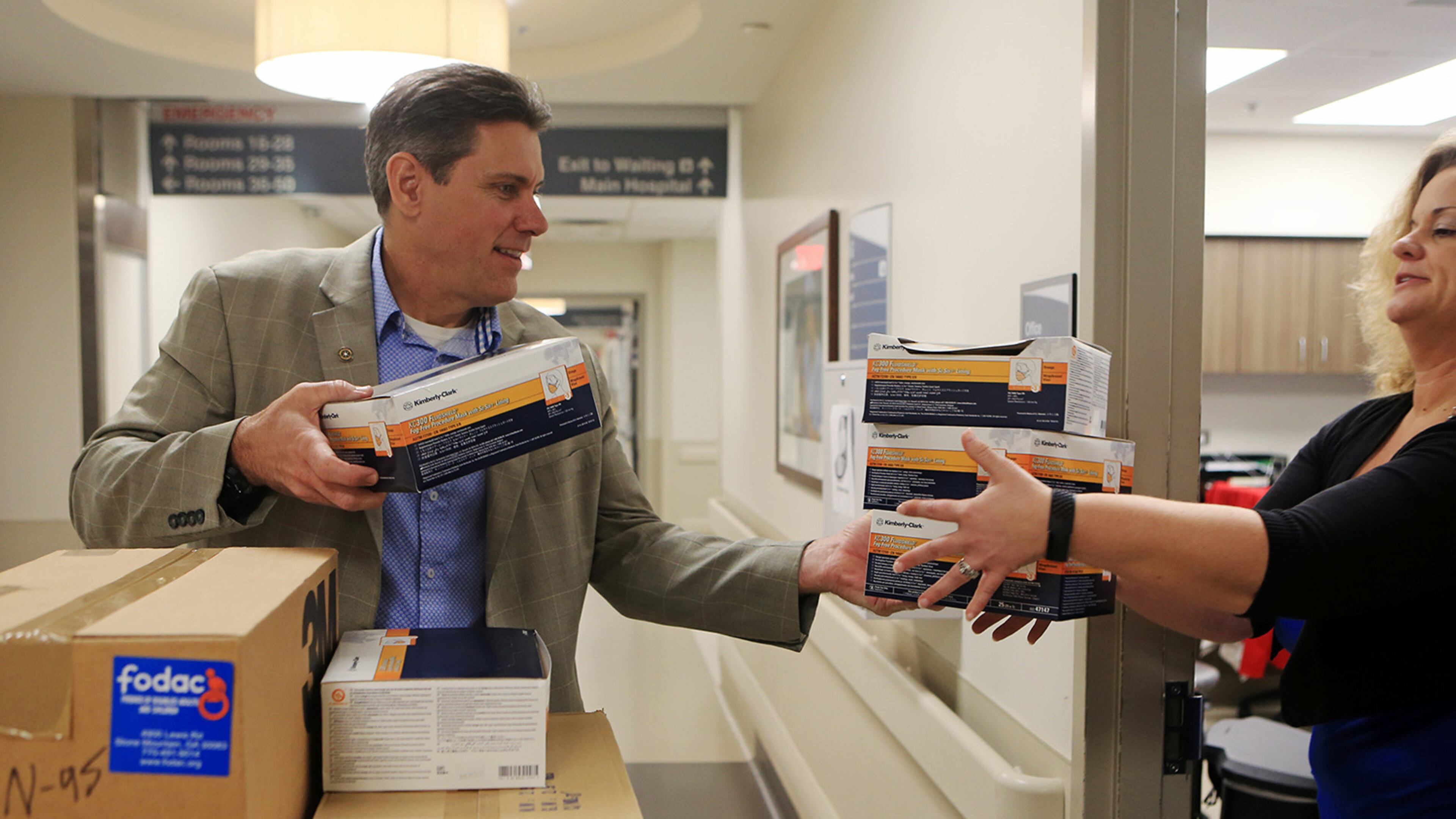 Chris Brand (left), president and CEO of FODAC, hands Laura Hochwalt, executive director of emergency and trauma at Grady Hospital, donated masks and medical supplies on Tuesday, March 24, 2020, at Grady Hospital in Atlanta. FODAC, Friends of Disabled Adults and Children, is an organization that provides wheelchairs and other medical equipment to disabled people. In the midst of the CO-VID 19 outbreak, the organization has focused on delivering masks, gloves and other in-demand supplies to hospitals. (Christina Matacotta, for The Atlanta Journal-Constitution)