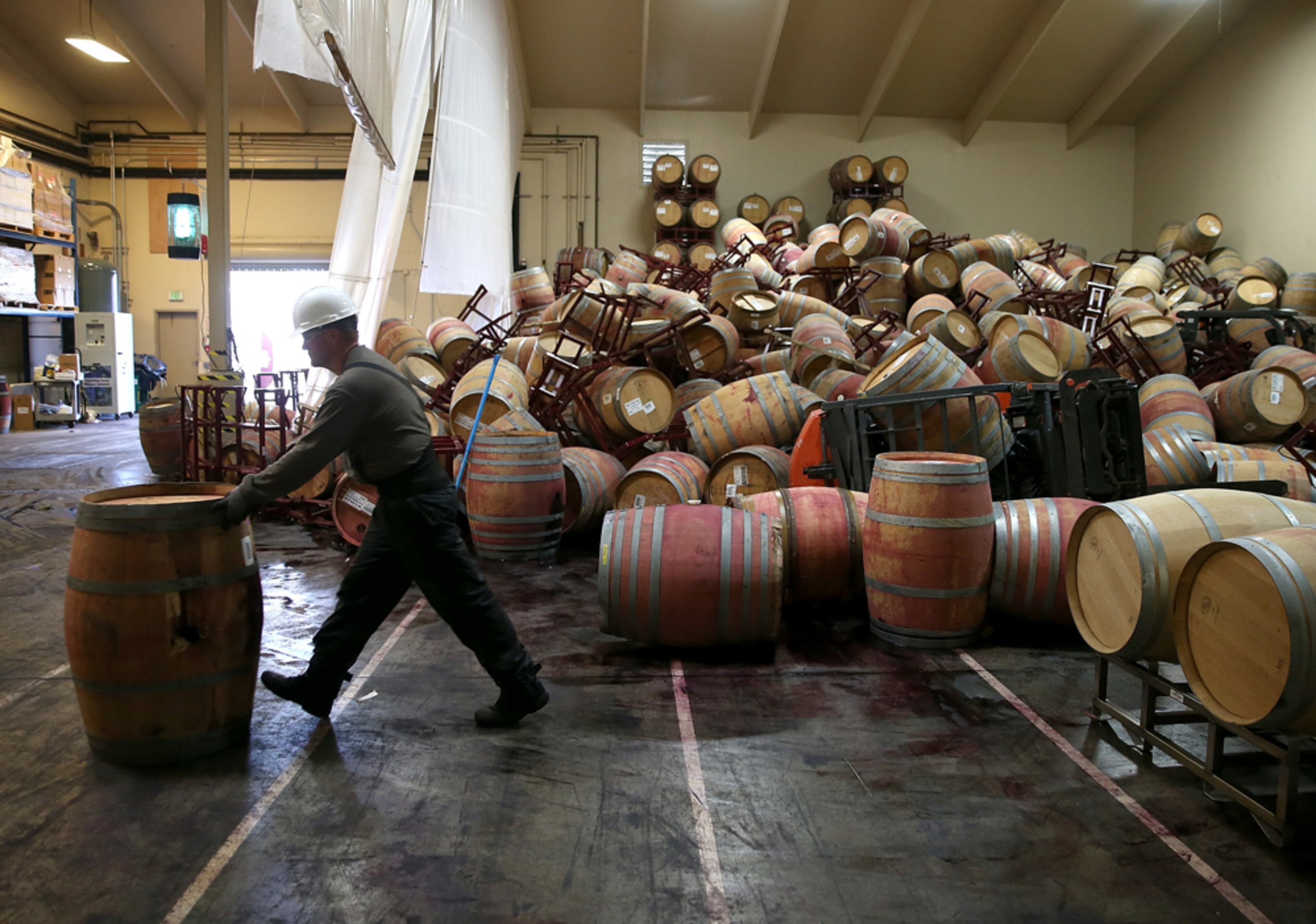 WINERY CLEANUP--NAPA, CA - AUGUST 25: Cellar worker Adam Craig moves a wine barrel as he cleans up a pile of collapsed barrels in a storage room at Kieu Hoang Winery on August 25, 2014 in Napa, California. A day after a 6.0 earthquake rocked the Napa Valley, residents and wineries are continuing clean up operations. (Photo by Justin Sullivan/Getty Images)