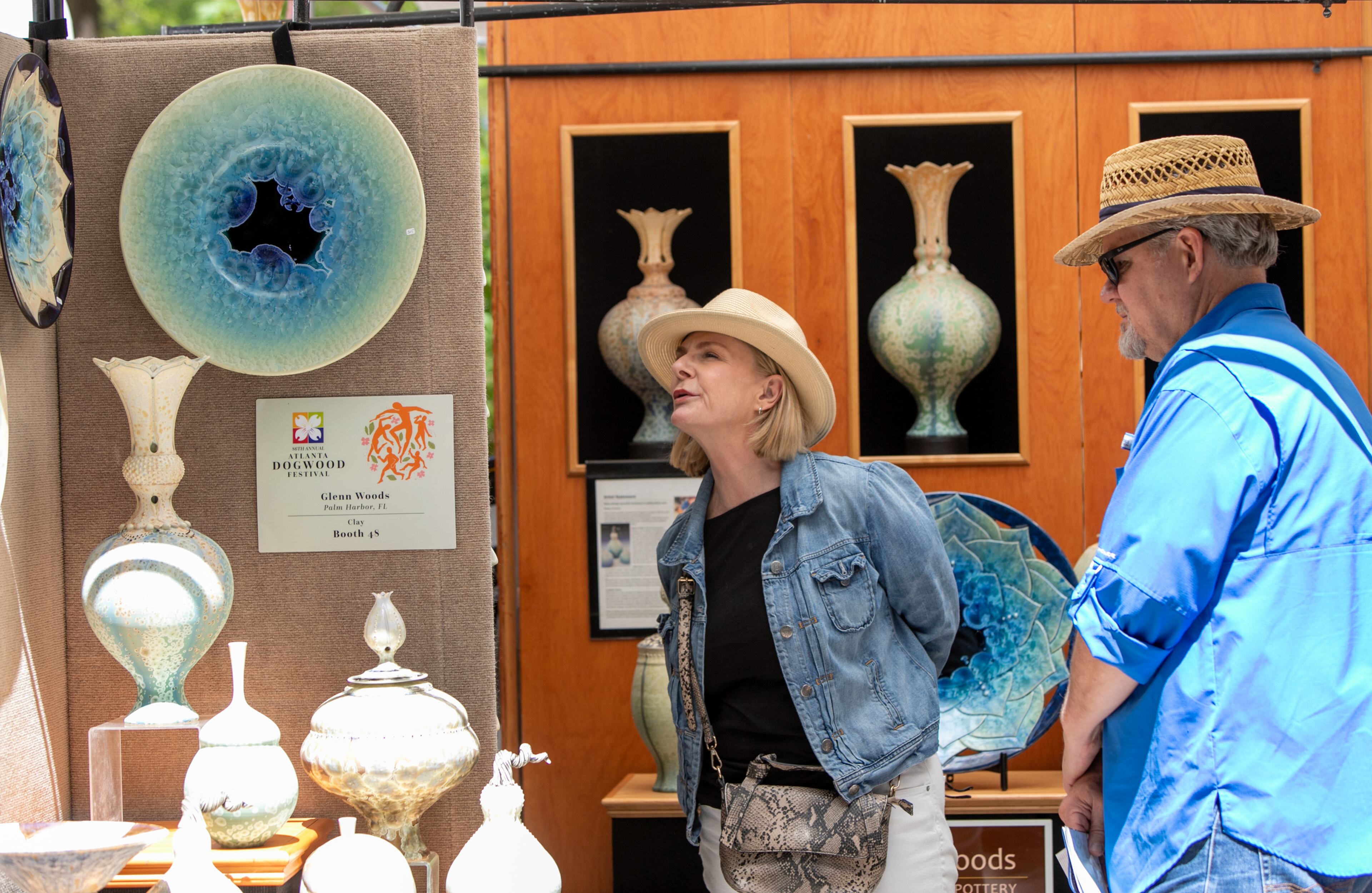 Vanessa Hebert, left, and BJ Bryan takes a look at the crystalline pottery made by Glenn Woods, shop Sunday, April 10, 2022, at the 86th annual Atlanta Dogwood Festival in Piedmont Park. (Jenni Girtman for The Atlanta Journal-Constitution)