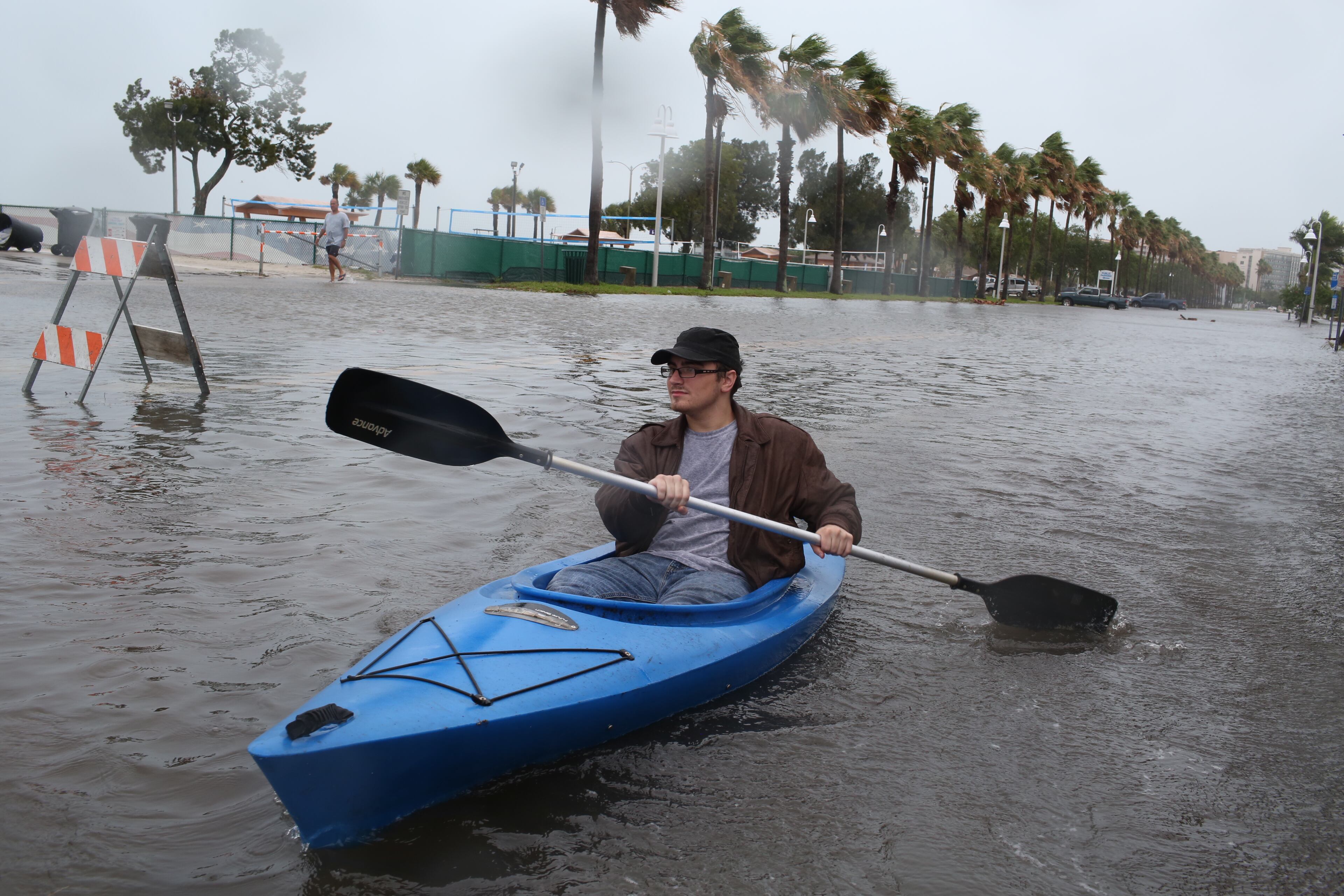 Nick Canning, 21, kayaks in downtown Gulfport, Fla., Monday, June 6, 2016 as rain and wind from Tropical Storm Colin blow into Tampa Bay, Fla. Canning lives in Gulfport. His alley is flooded, but his home has not taken water. (John Pendygraft/Tampa Bay Times via AP)