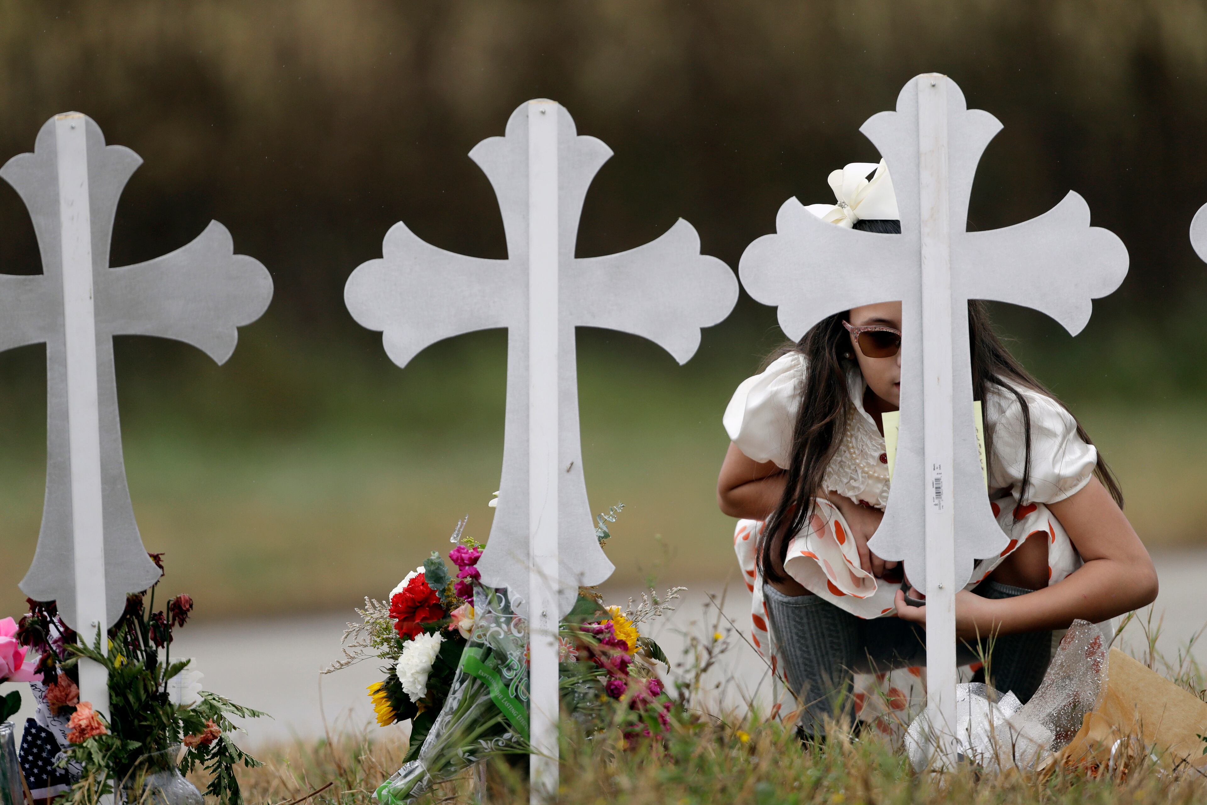 Meredith Cooper visits a makeshift memorial following a worship service for the victims of the shooting at Sutherland Springs Baptist Church, Sunday, Nov. 12, 2017, in Sutherland Springs, Texas. A man opened fire inside the church in the small South Texas community last week, killing more than two dozen. (AP Photo/Eric Gay)