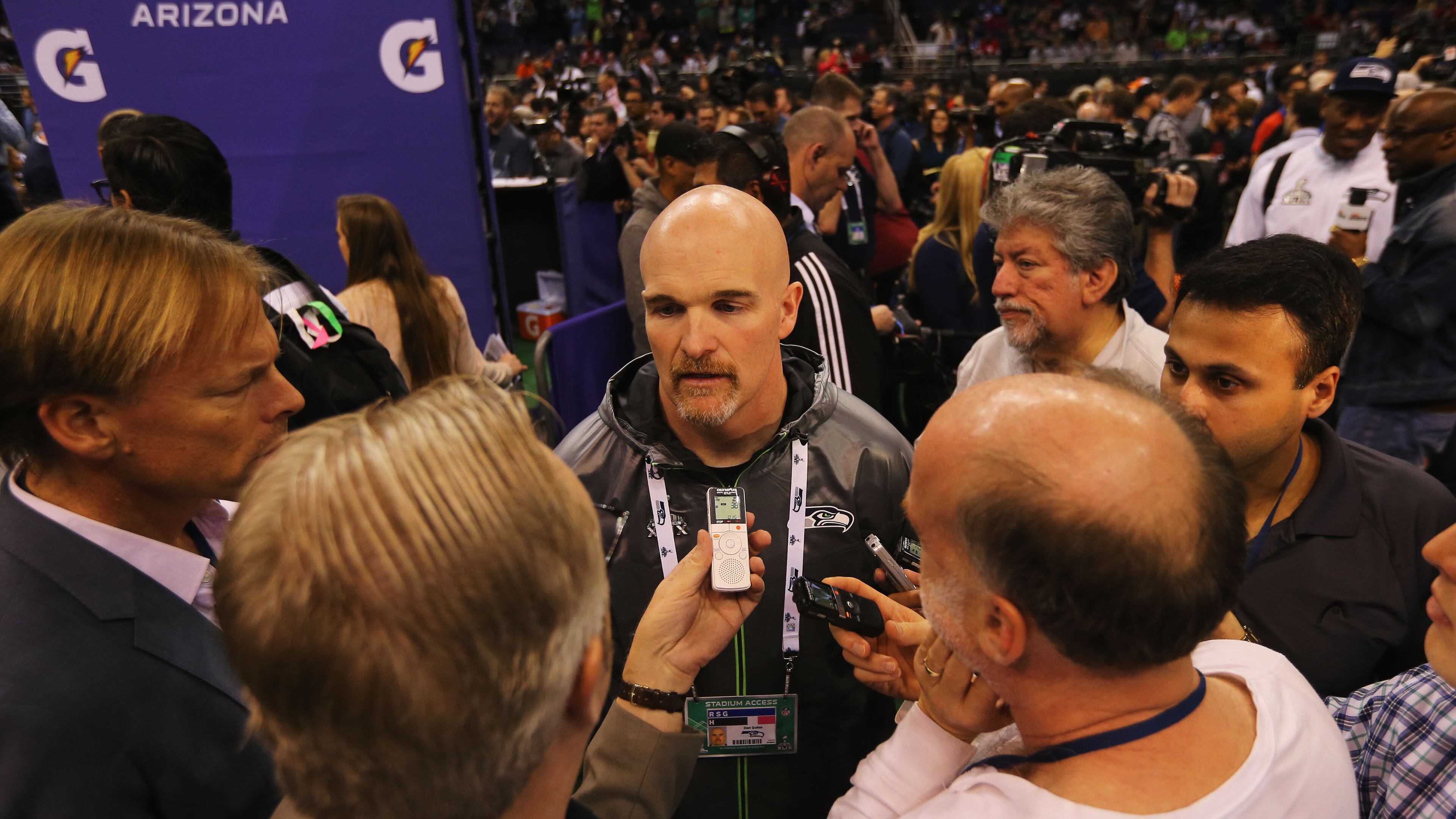 PHOENIX, AZ - JANUARY 27: Defensive coordinator Dan Quinn of the Seattle Seahawks addresses the media at Super Bowl XLIX Media Day Fueled by Gatorade inside U.S. Airways Center on January 27, 2015 in Phoenix, Arizona. (Photo by Elsa/Getty Images) Noteworthy: Dan Quinn has less hair than at least one Atlanta media member pictured. (Getty Images)
