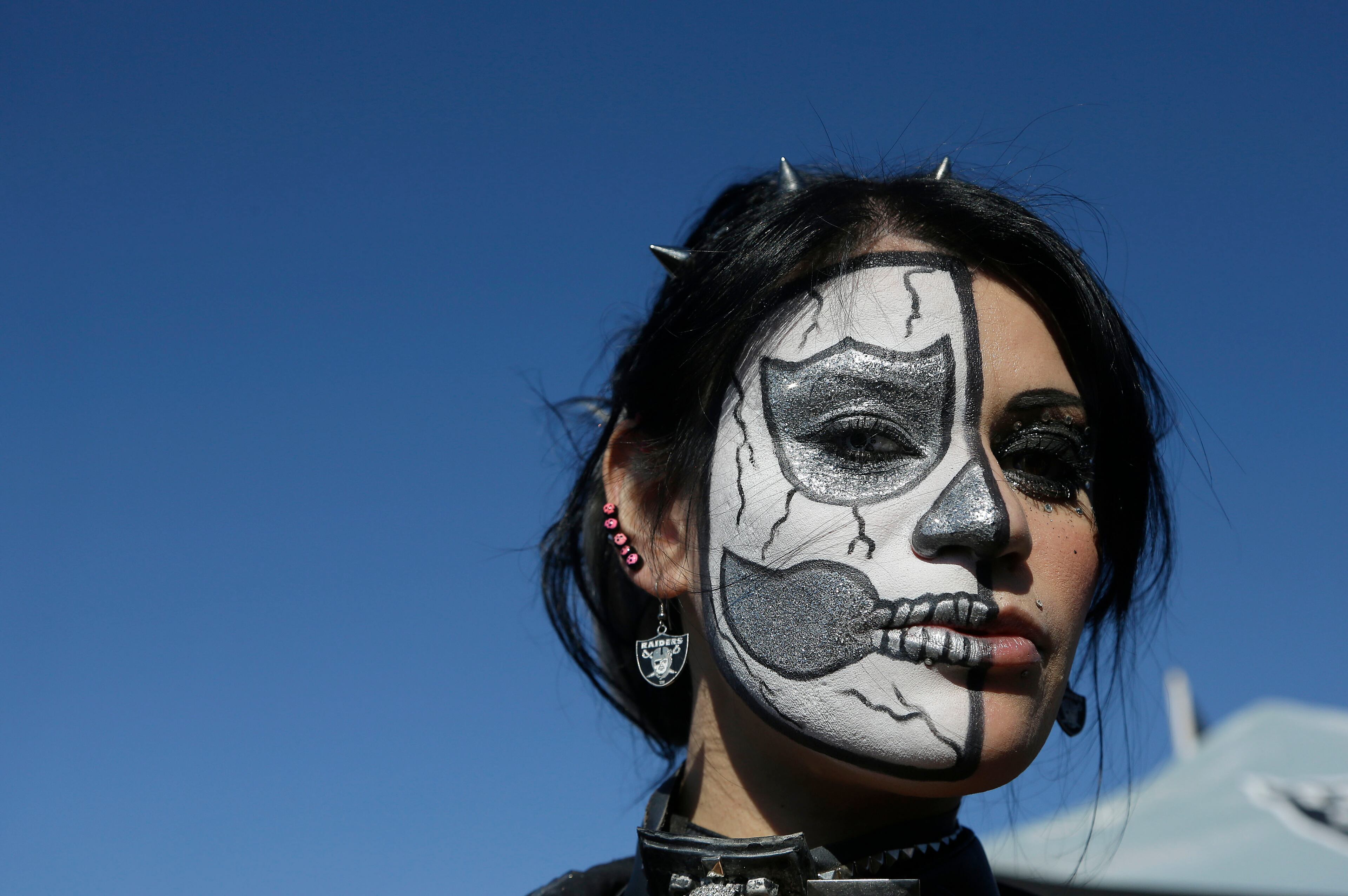 Oakland Raiders fan Cindy Reyna, aka Metal Cindy, poses for photographs in the O.co Coliseum parking lot before an NFL football game between the Oakland Raiders and the Tennessee Titans in Oakland, Calif., Sunday, Nov. 24, 2013. (AP Photo/Jeff Chiu)