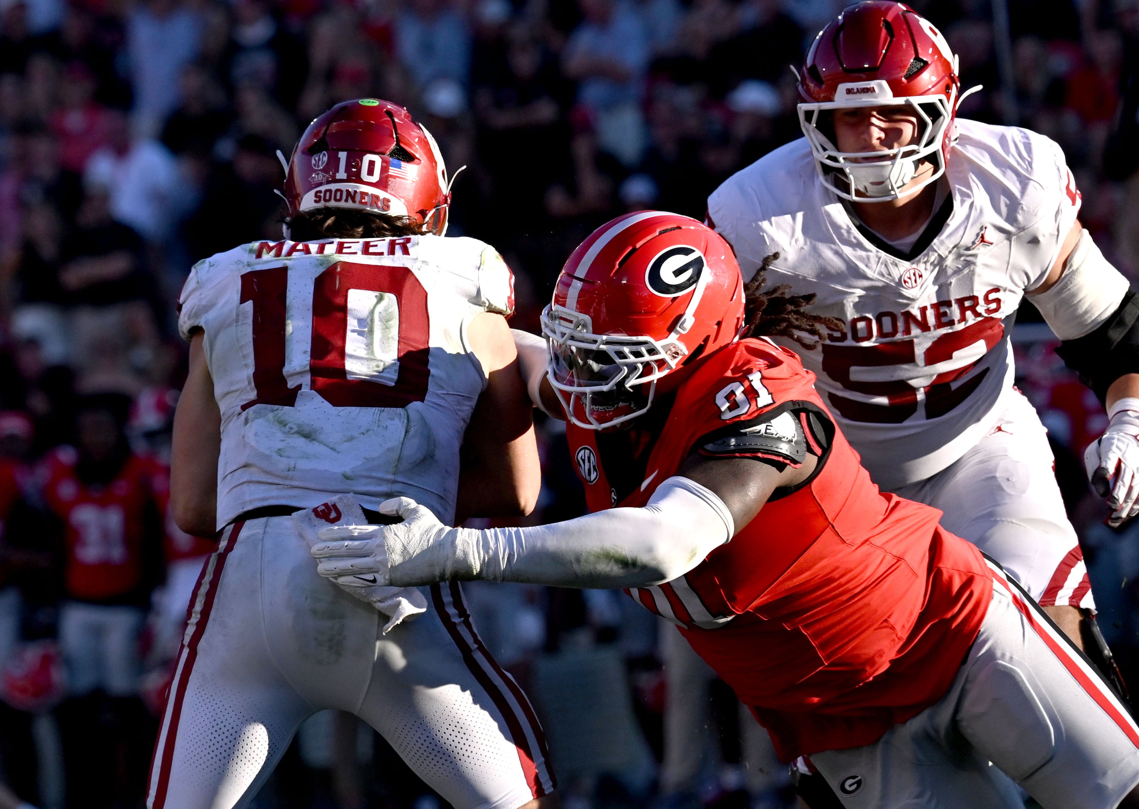 Oklahoma quarterback John Mateer (left) is sacked by Georgia defensive lineman Josh Horton during the second half of an NCAA football game at Sanford Stadium on Saturday, Sept. 26, 2026, in Athens, Ga. Georgia defeated Oklahoma 41-13. (Hyosub Shin/AJC)