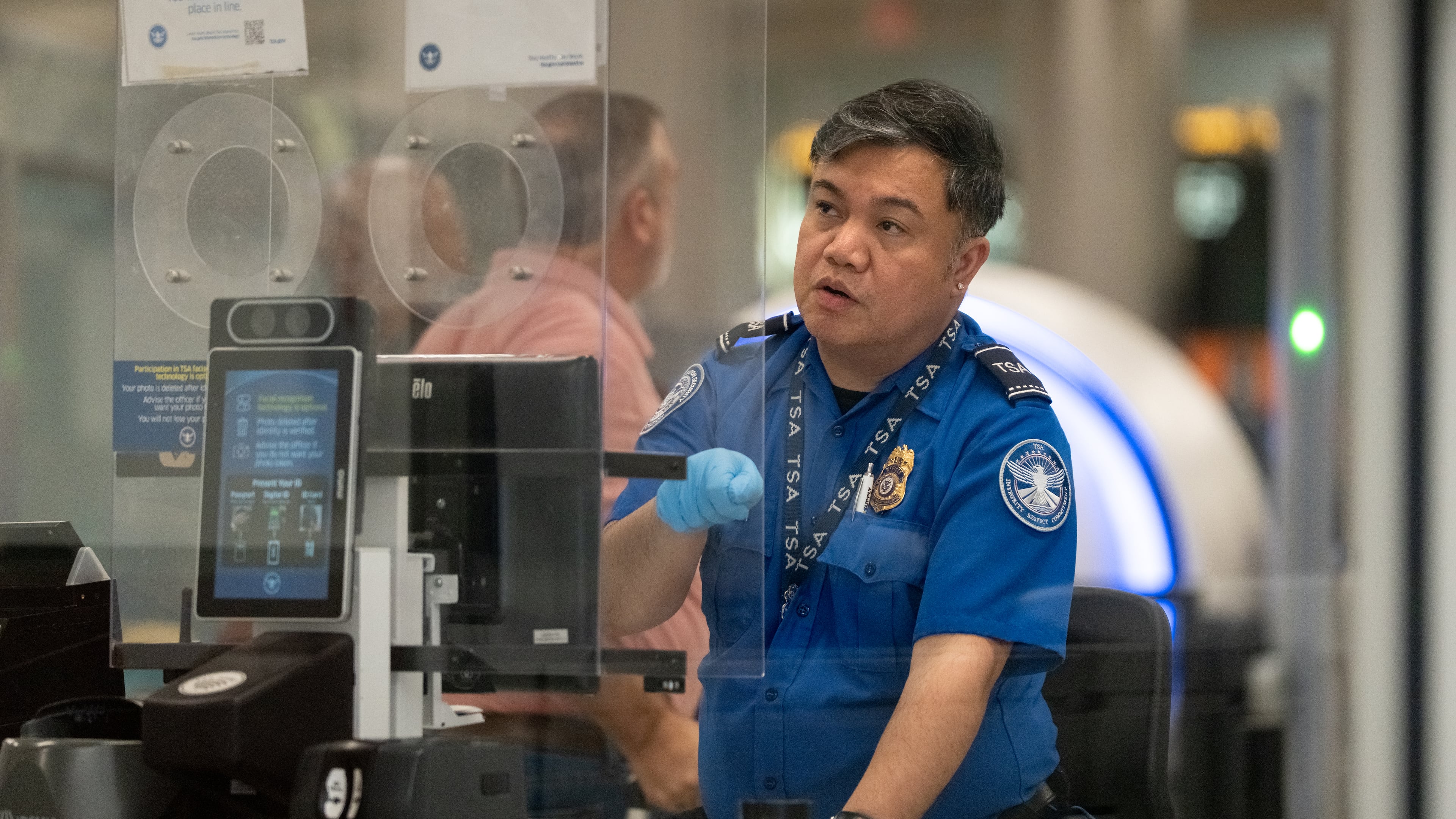 A Transportation Security Administration officer checks the identification of travelers at Hartsfield-Jackson Atlanta International Airport on Wednesday, Oct. 1, 2025 (Ben Hendren for the AJC)