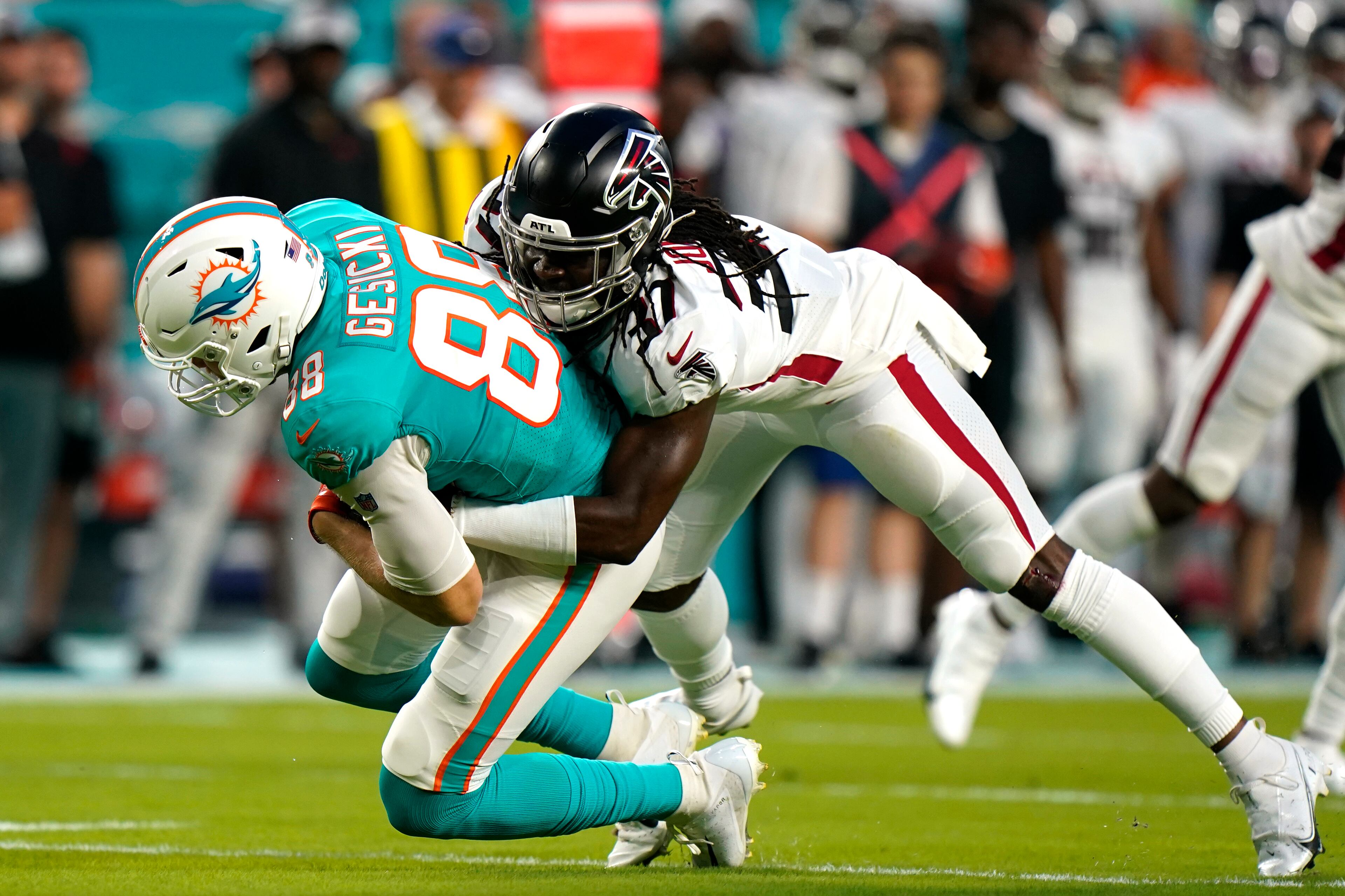 Atlanta Falcons safety Dwayne Johnson Jr. (37) tackles Miami Dolphins tight end Mike Gesicki (88) during the first half of a NFL preseason football game, Saturday, Aug. 21, 2021, in Miami Gardens. (AP Photo/Wilfredo Lee)