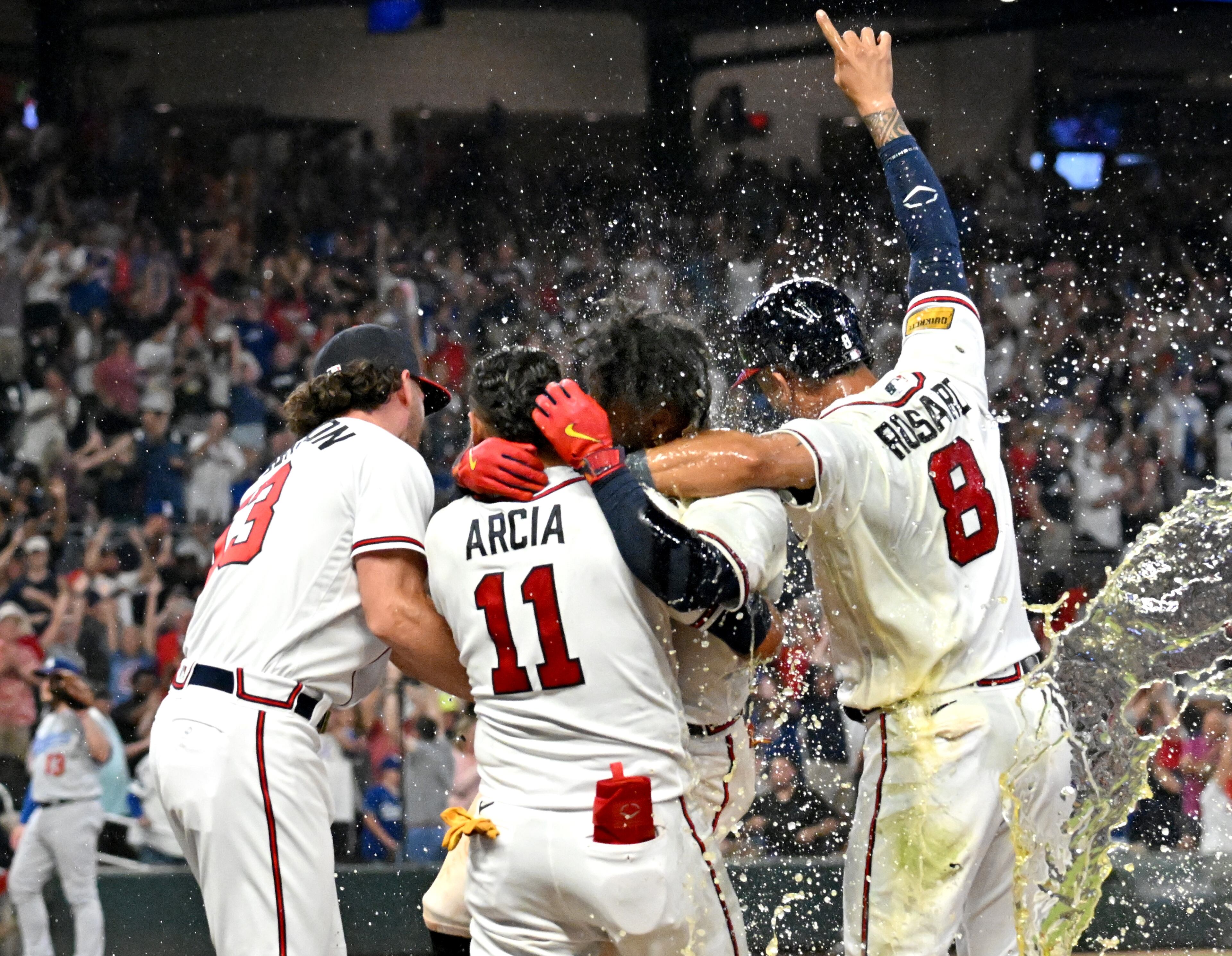 Braves players celebrate with second baseman Ozzie Albies (third from left) after his flyball drove in Austin Riley in the ninth inning to beat the Dodgers 4-3 at Truist Park, Wednesday, May 24, 2023. (Hyosub Shin / Hyosub.Shin@ajc.com)
