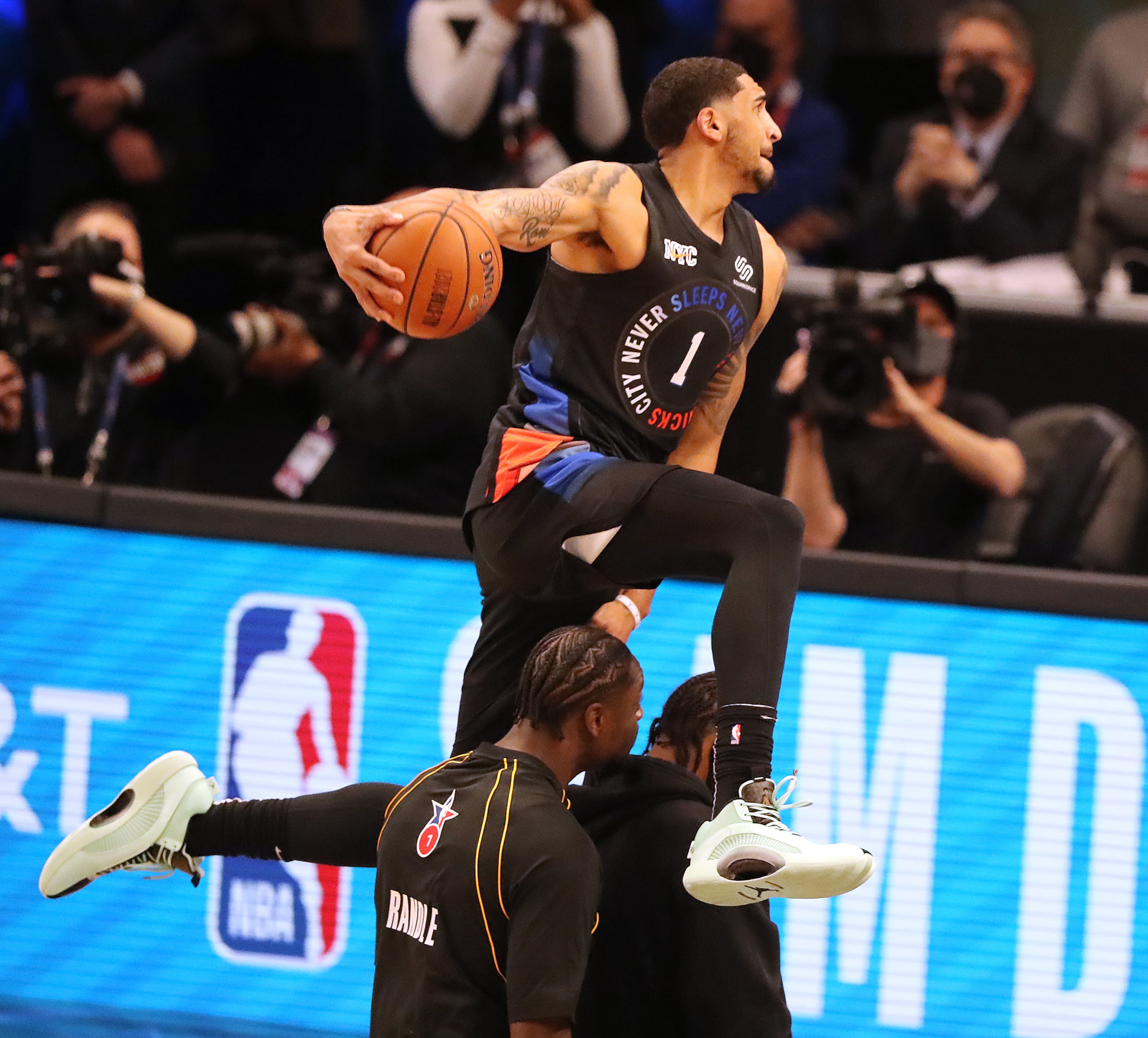 Obi Toppin goes over two teammates during his attempt in the Slam Dunk contest of the 2021 NBA All-Star Game Sunday, March 7, 2021, at State Farm Arena in Atlanta. (Curtis Compton / Curtis.Compton@ajc.com)
