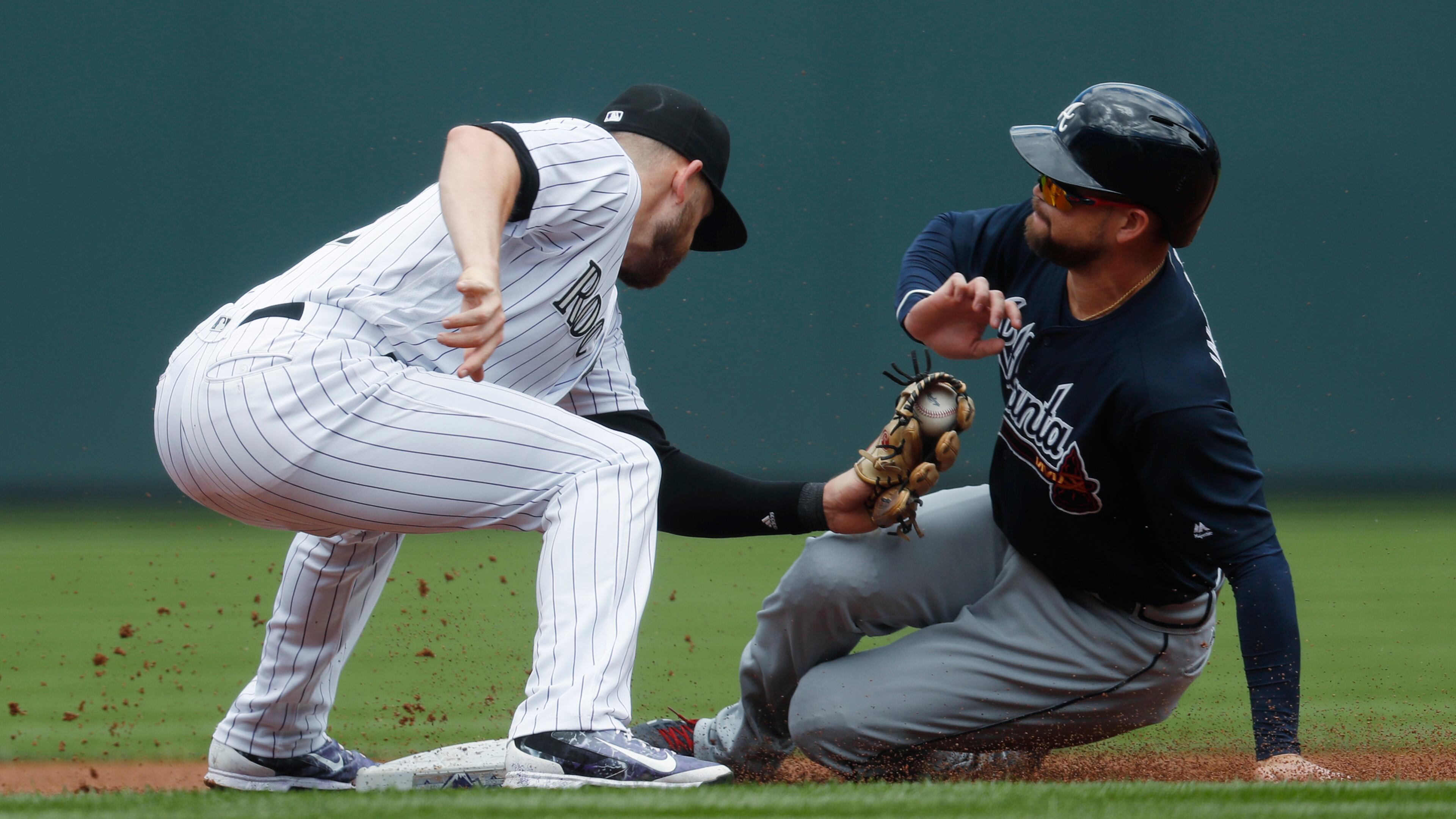 Colorado Rockies shortstop Trevor Story, left, applies a late tag on Atlanta Braves’ Ender Inciarte as Inciarte steals second base in the first inning of a baseball game Thursday, Aug. 17, 2017, in Denver. (AP Photo/David Zalubowski)