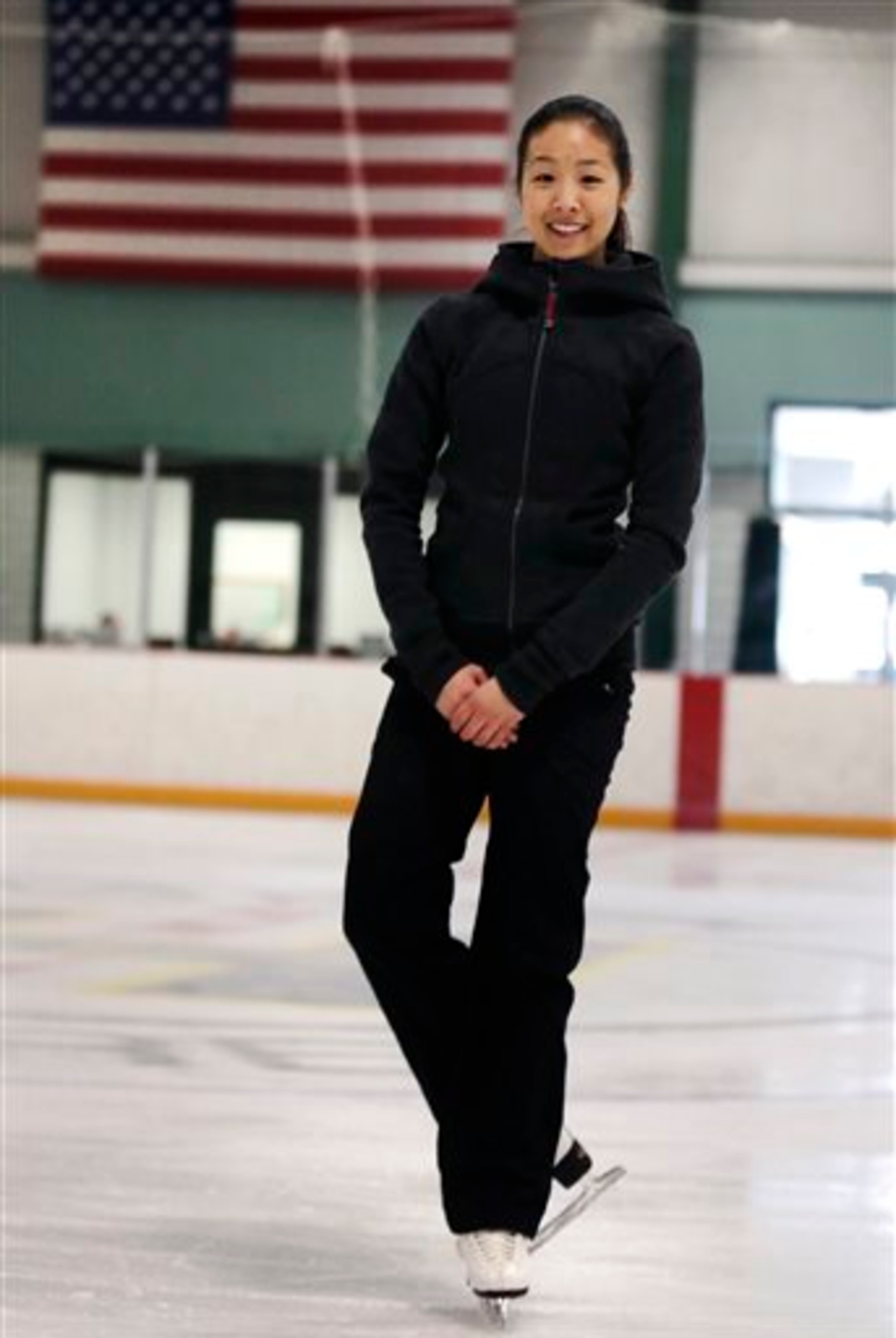 In this Wednesday, March 19, 2014 photo, Devin Wang, a Boston University student and skater with the USA synchronized skating team known as the Haydenettes, stands on the ice rink before a practice in Lexington, Mass. Wang, along with bystander Carlos Arredondo and EMT Paul Mitchell, are credited with helping to save the life of Jeff Bauman, who suffered traumatic injuries in the Boston Marathon bombings. (AP Photo/Charles Krupa)
