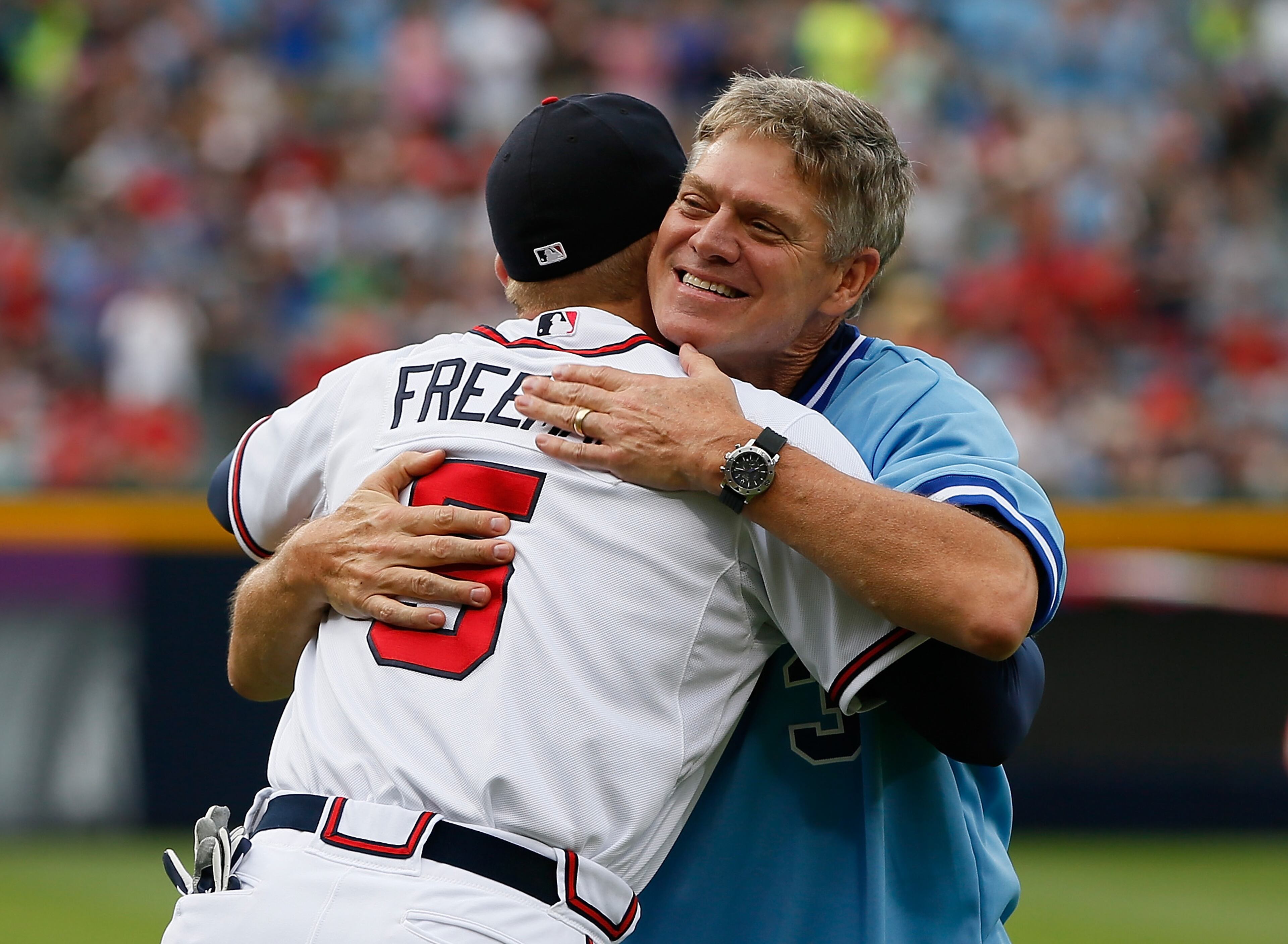 Former Atlanta Brave Dale Murphy hugs Freddie Freeman #5 of the Atlanta Braves after throwing out the ceremonial first pitch prior to the game against the Cincinnati Reds at Turner Field on July 11, 2013 in Atlanta, Georgia.