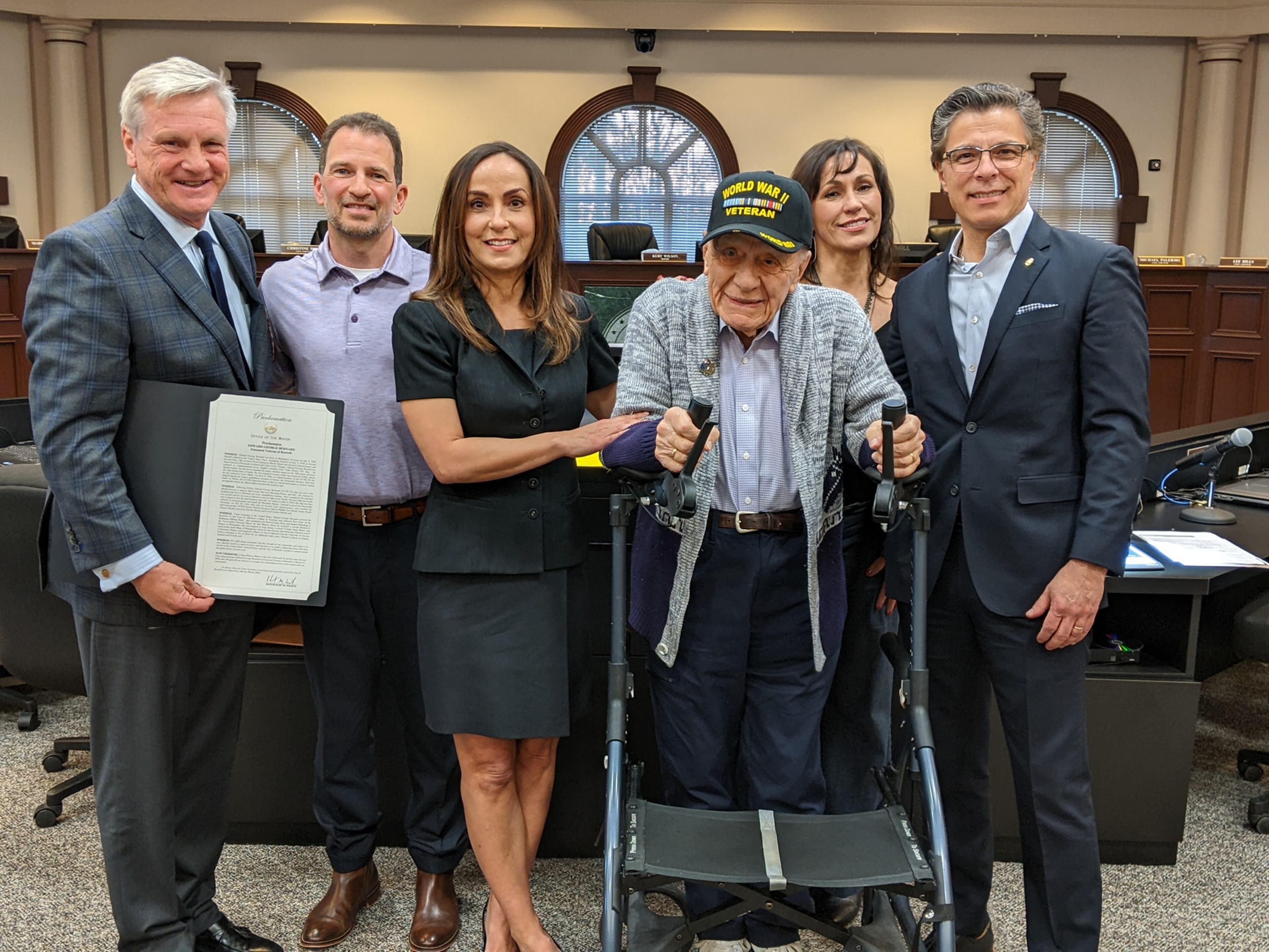 During a Roswell City Council meeting, Mayor Kurt Wilson presented Edward G. Bernard with a city proclamation naming him an “esteemed veteran of Roswell.”
Bernard is standing with his walker. Also, pictured are Mayor Kurt Wilson, Joe Baker, Bernard's son-in-law; and the honoree's children, daughters Jeannette, Carmen and Edward A. Bernard. Photo courtesy City of Roswell.